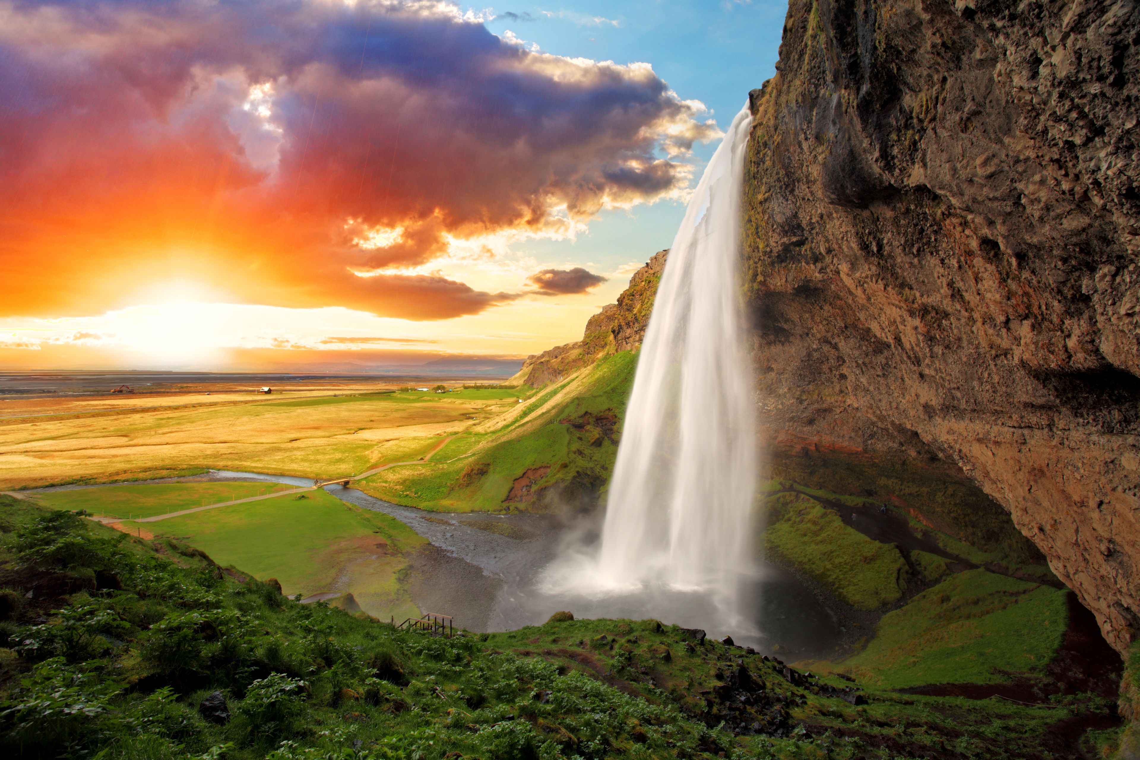 Seljalandsfoss waterfall with sunset and green grass 