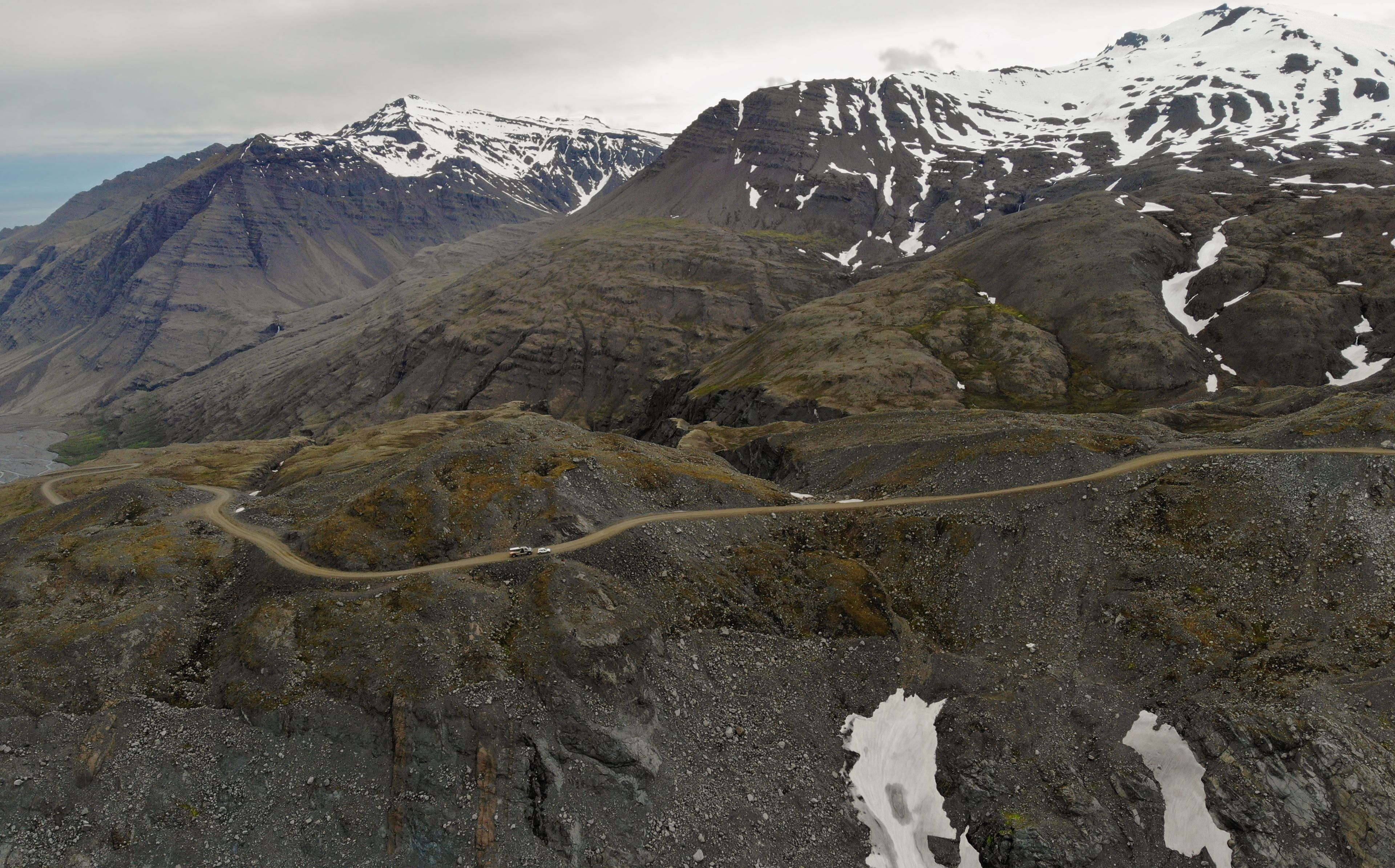 Aerial view of mountain road F985 leading to Joklasel and the Skalafellsjokull glacier, part of Vatnajökull National Park, Iceland. Panoramic landscape shot by drone camera.