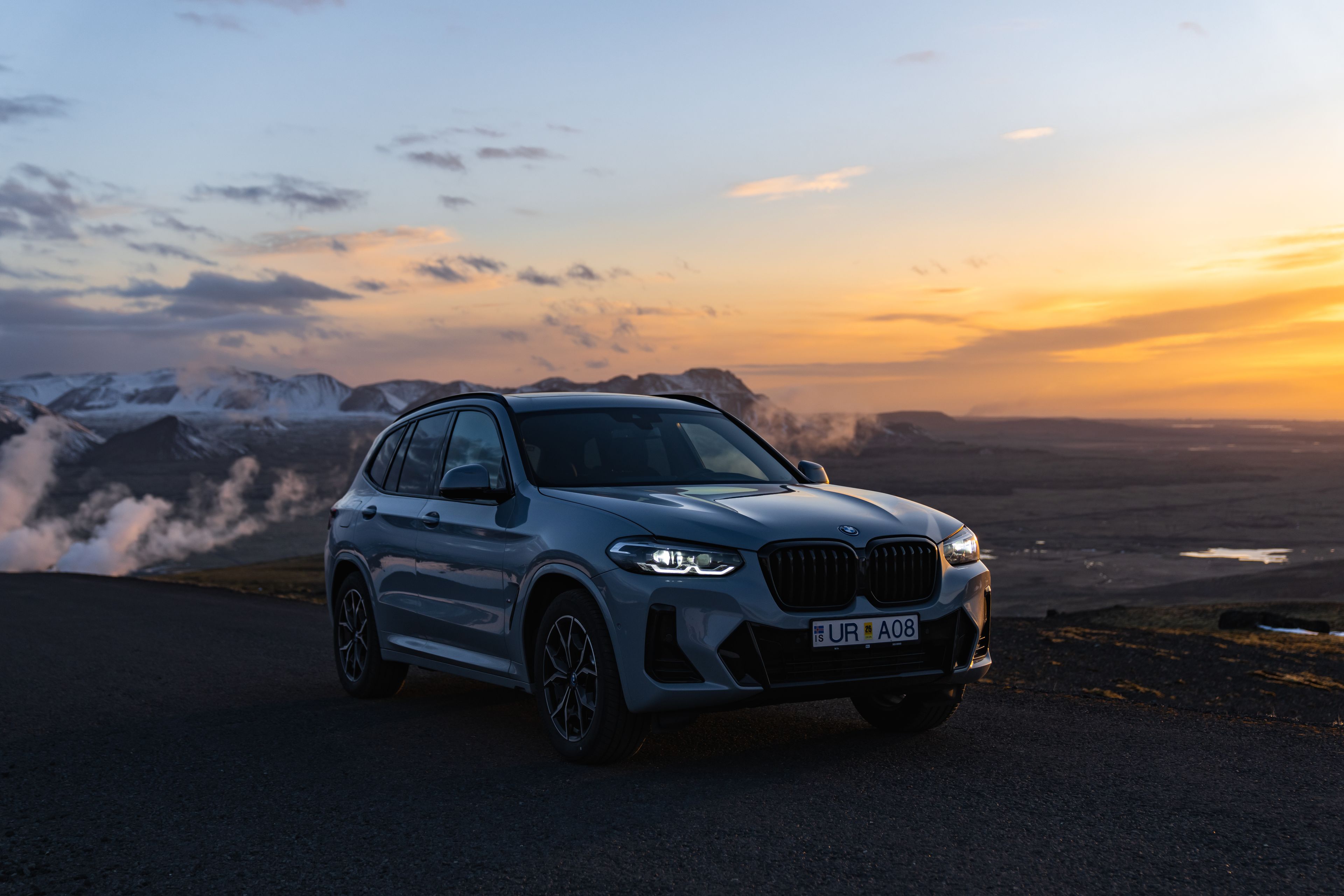 BMW X3 rental car parked against the backdrop of Iceland's stunning landscape