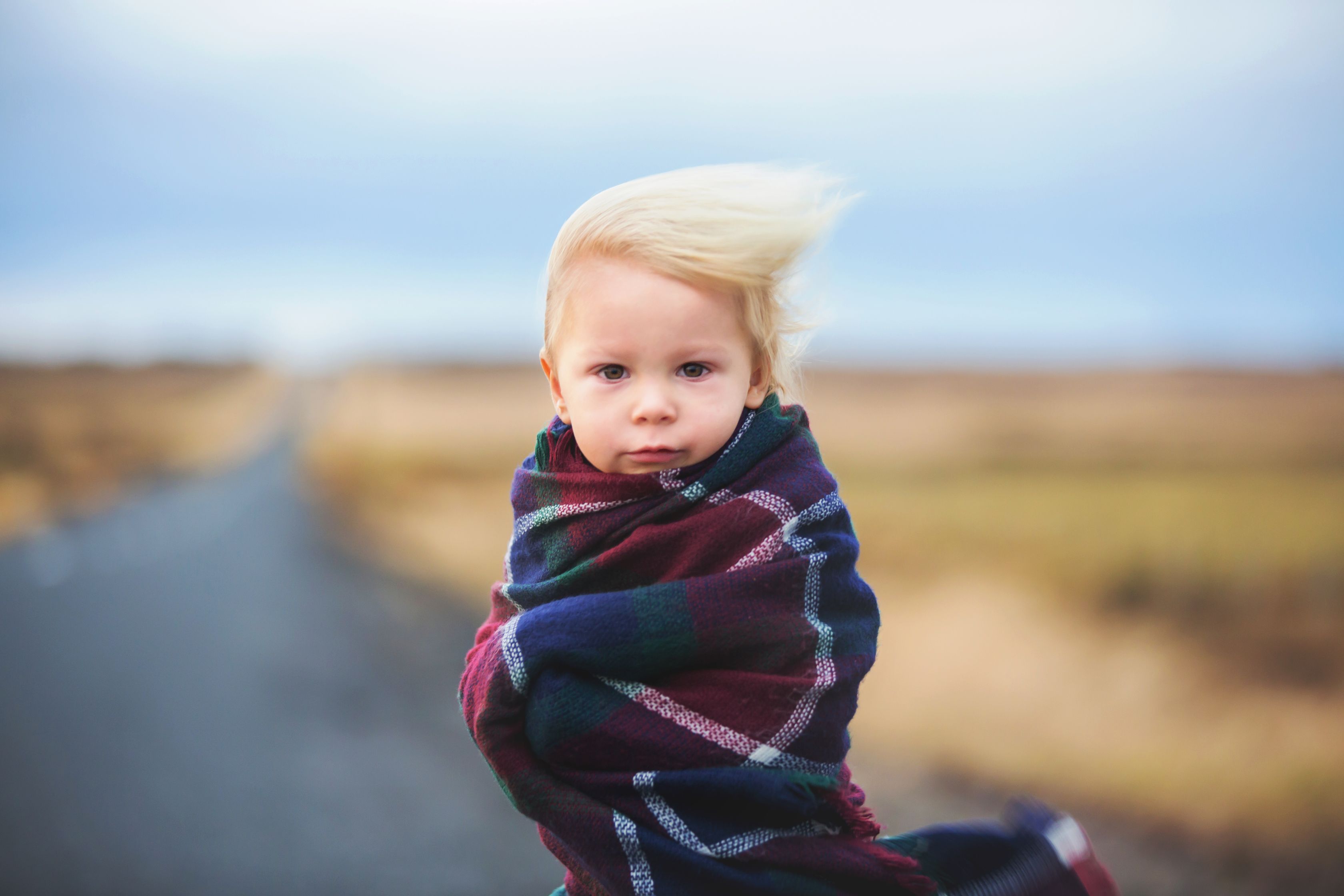 Kid standing in a road in Iceland on a very windy day