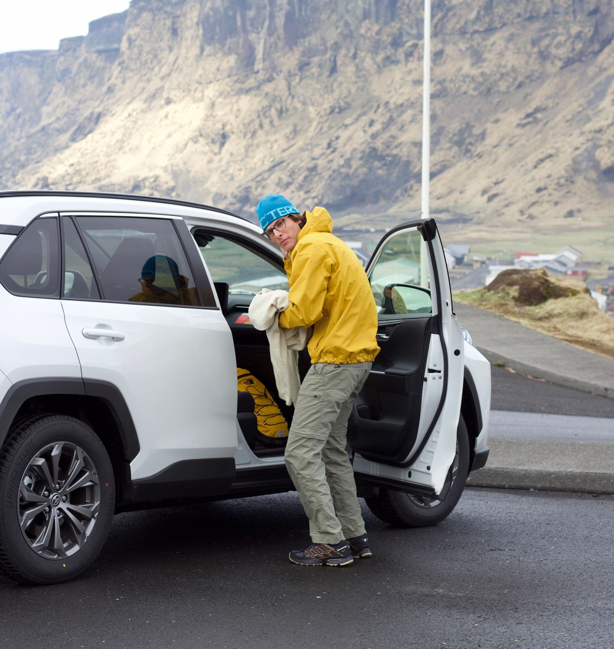 An adventurer stepping out of a Toyota Rav4 in the beautiful landscapes of Iceland