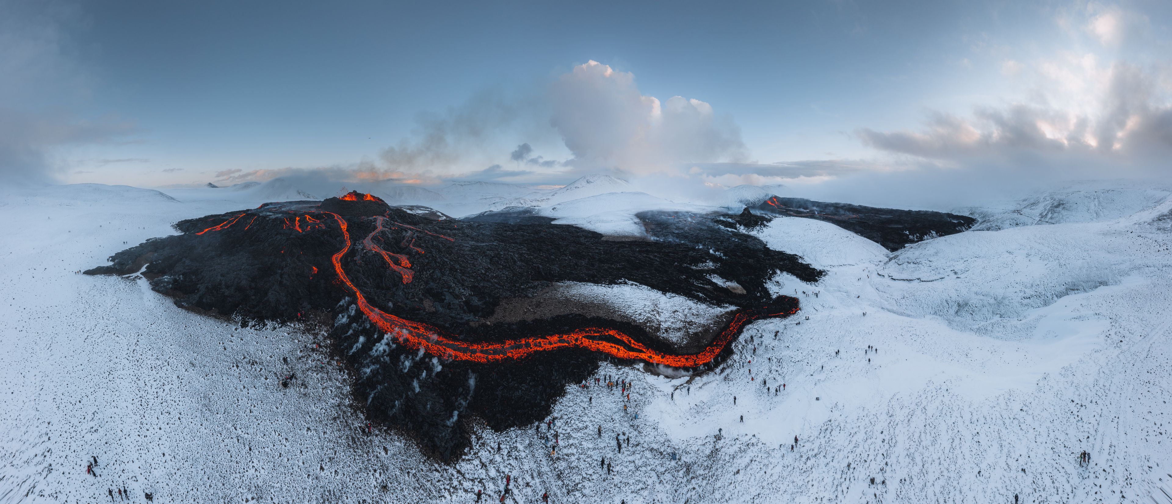 Icelandic landscape of a field with a lot of smoke and lava from a volcano