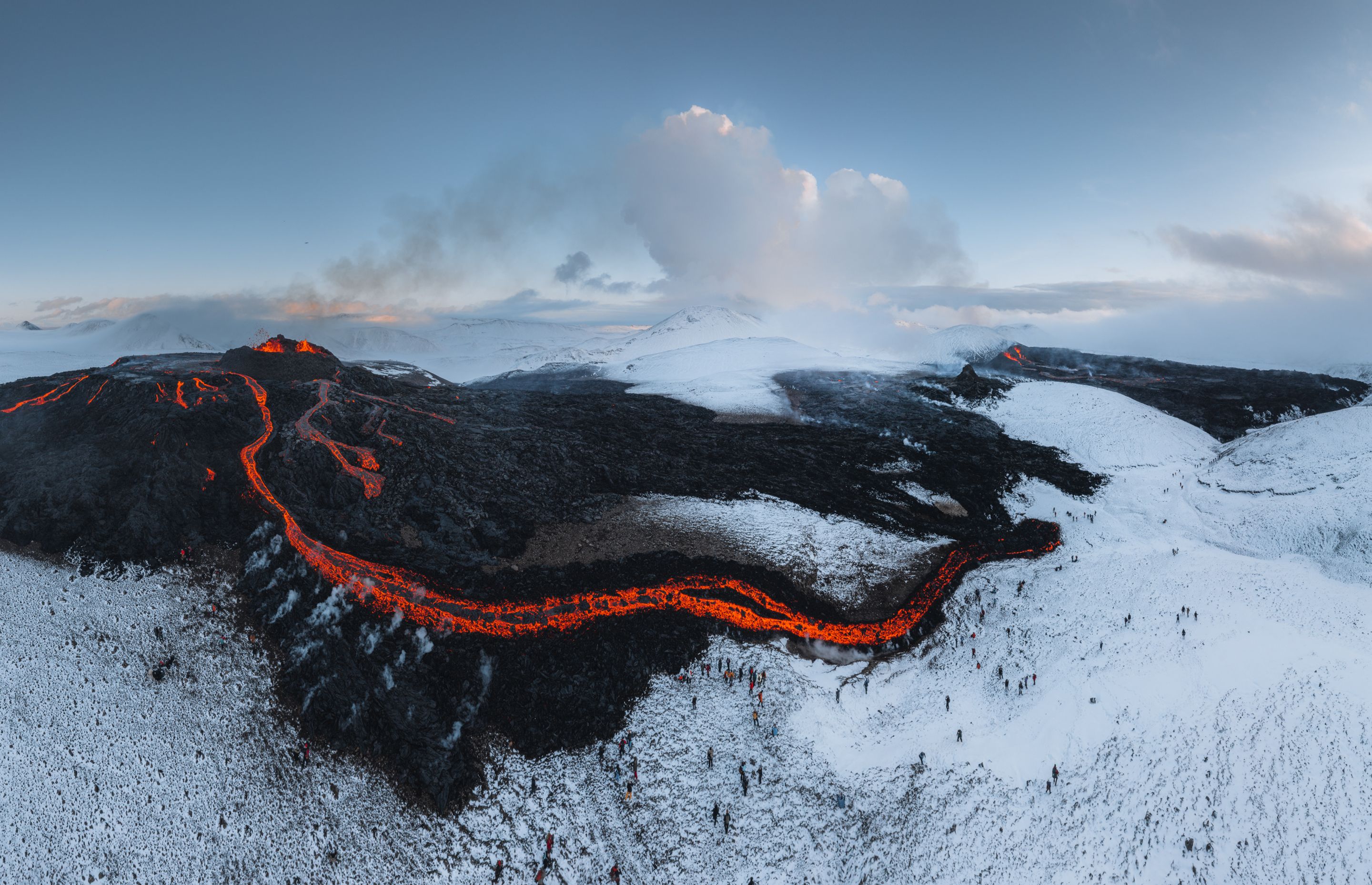 Icelandic landscape of a field with a lot of smoke and lava from a volcano