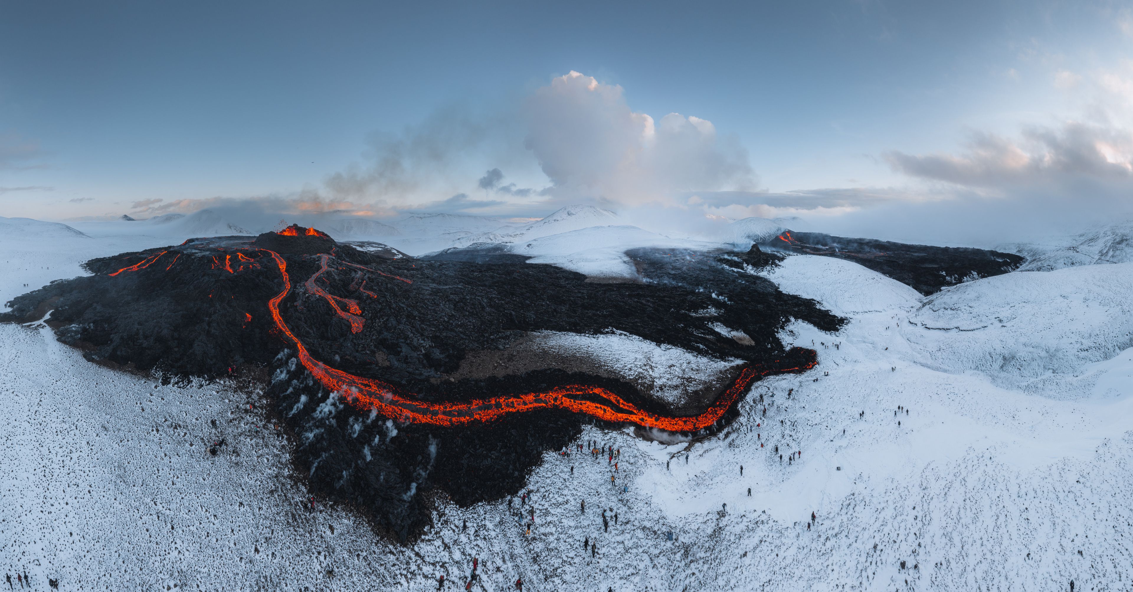 Icelandic landscape of a field with a lot of smoke and lava from a volcano