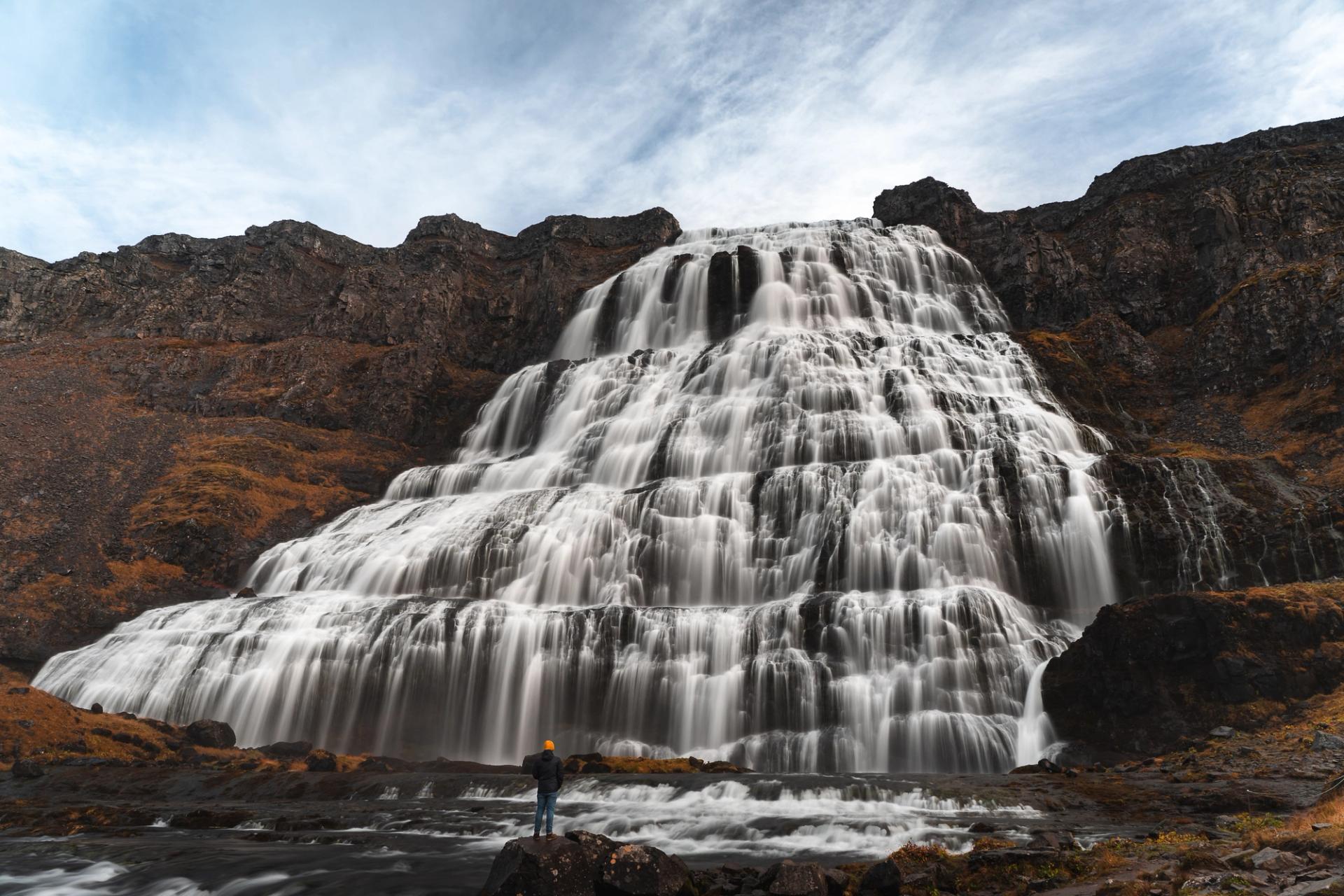A person impressed by the huge Dynjandi waterfall in Iceland
