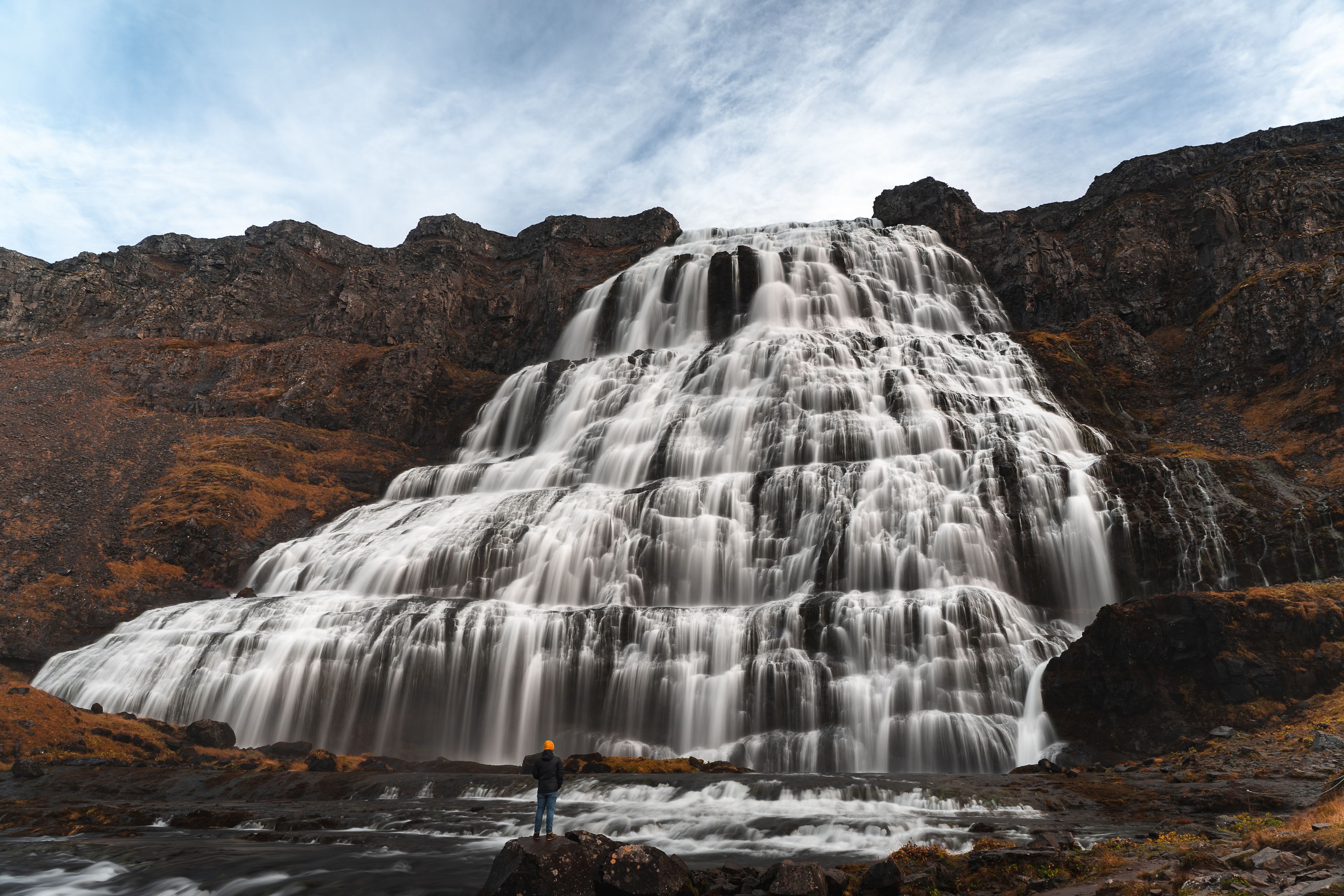 A person impressed by the huge Dynjandi waterfall in Iceland