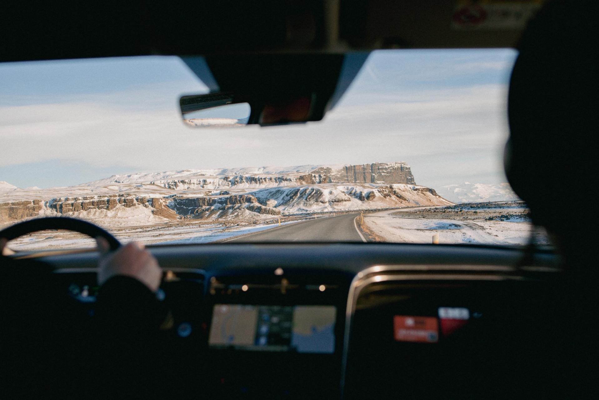 2 friends sitting in the front seats of a Iceland rental car