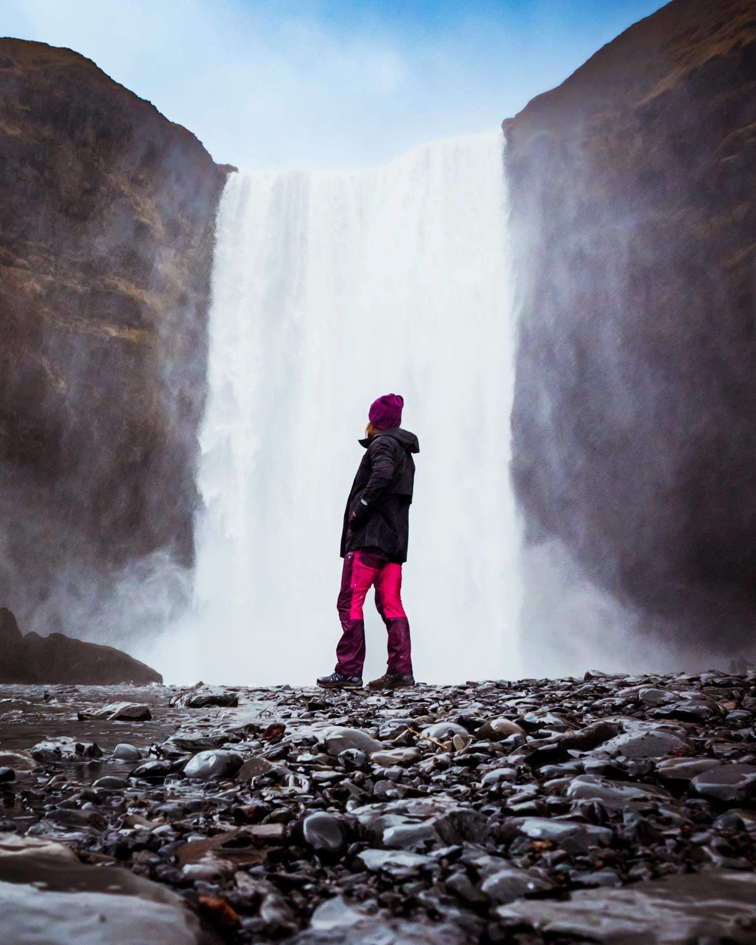 Girl dressing with waterproof jacket and pants, boots, and a hat