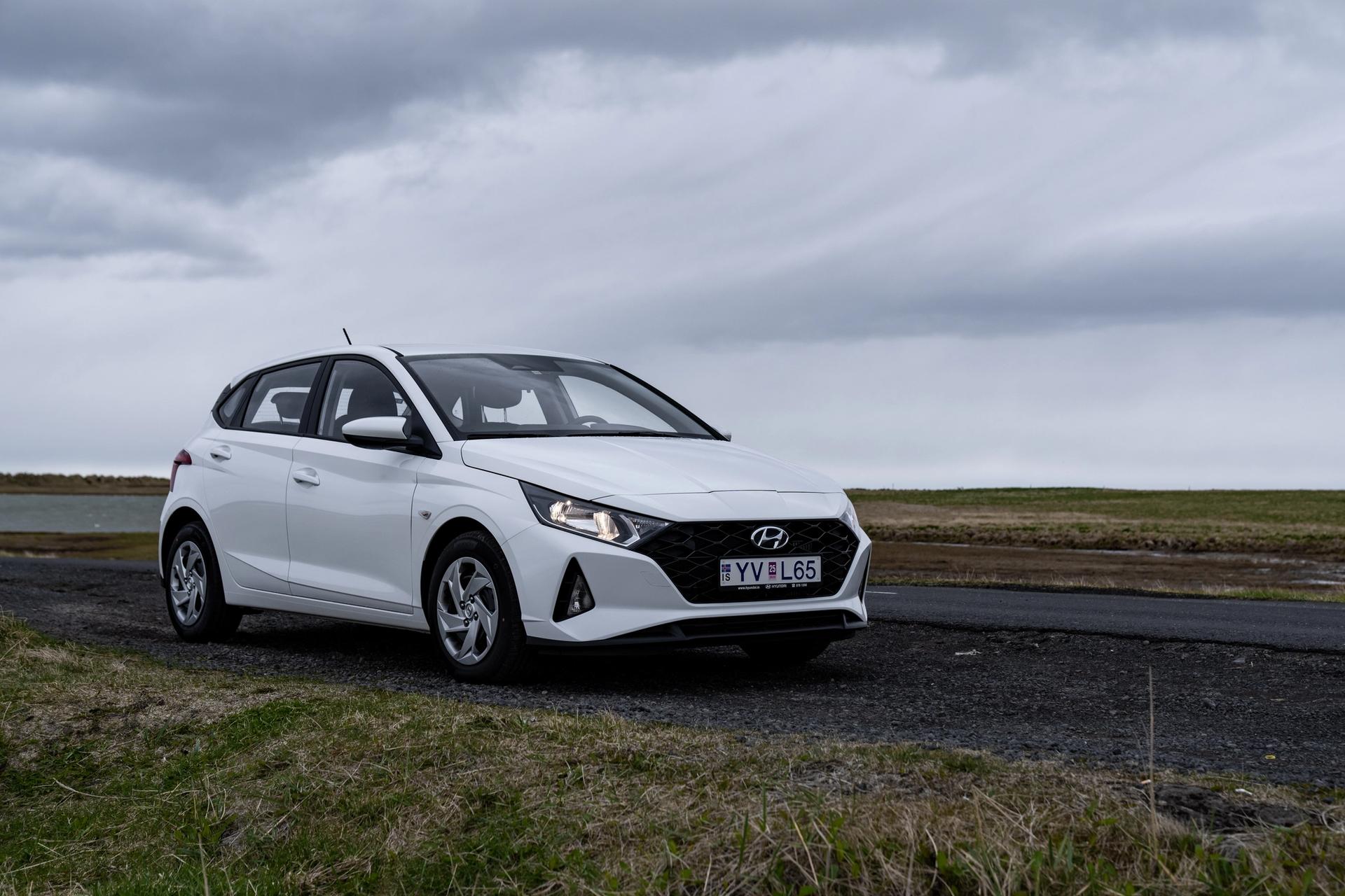 A sleek Hyundai i20, a great option for car rental in Iceland, parked against a beautiful Icelandic landscape.