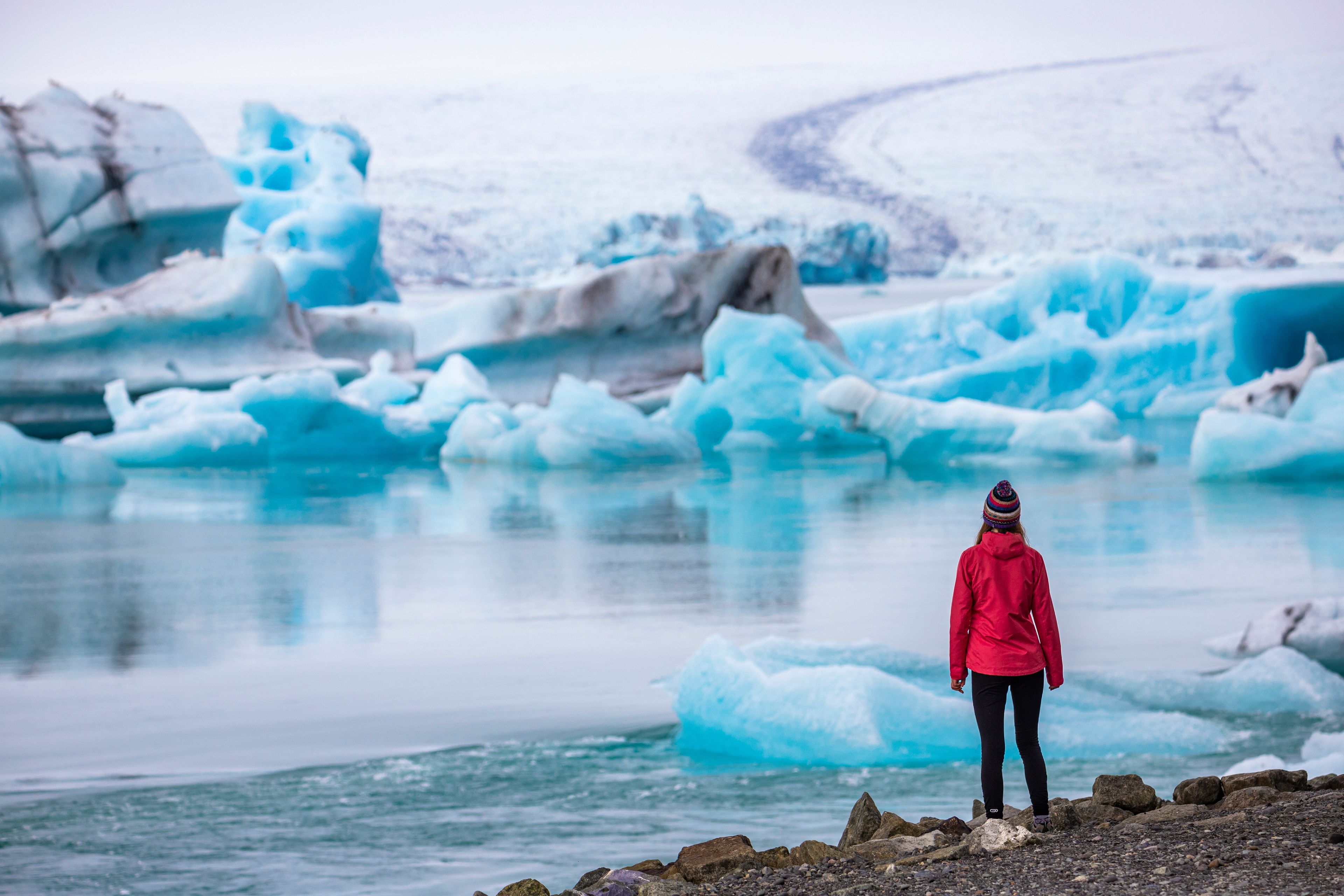 Girl on a red coat in front of Jökulsárlón Glacier Lagoon 