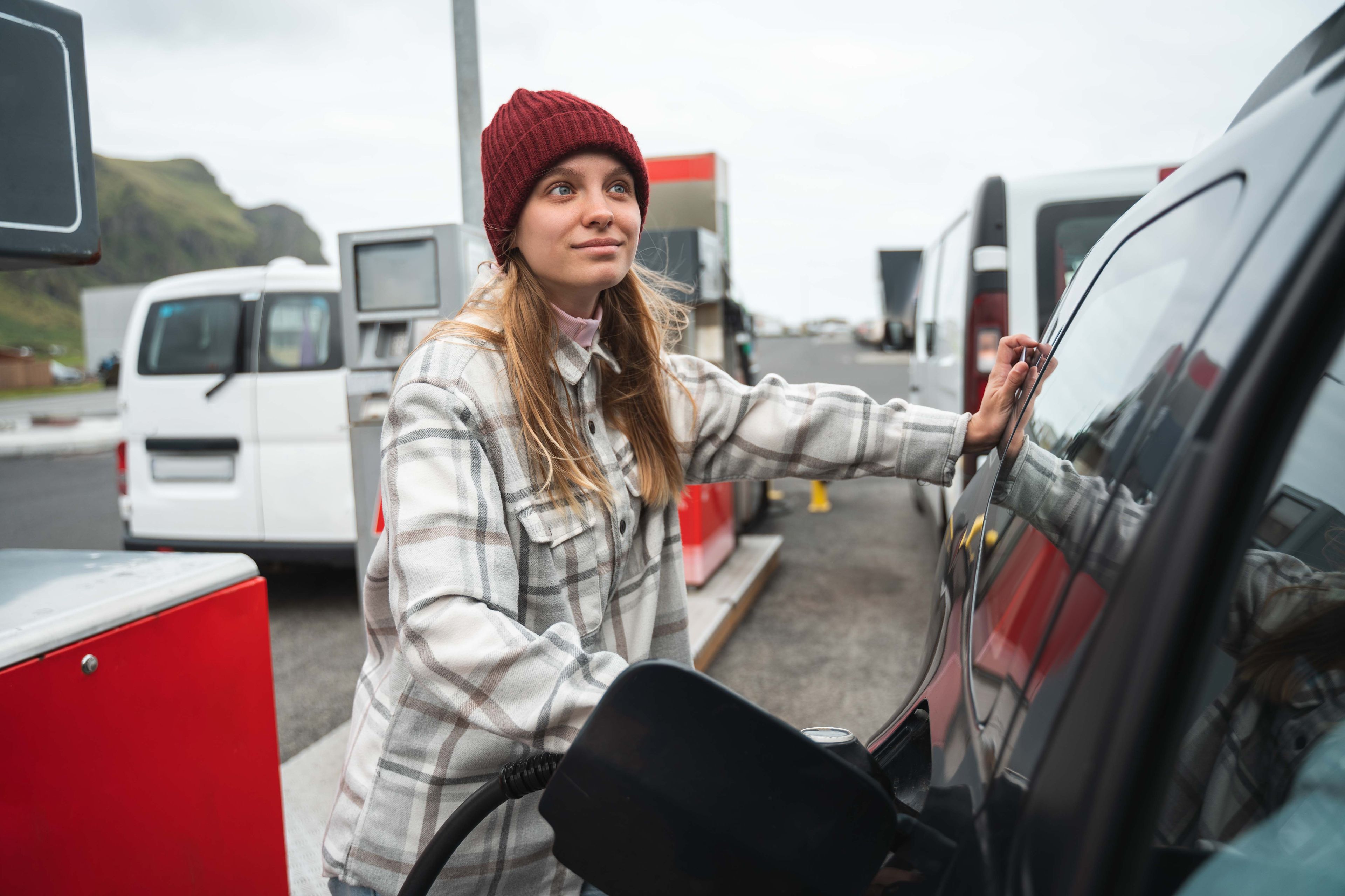 A woman filling up her rental car in iceland