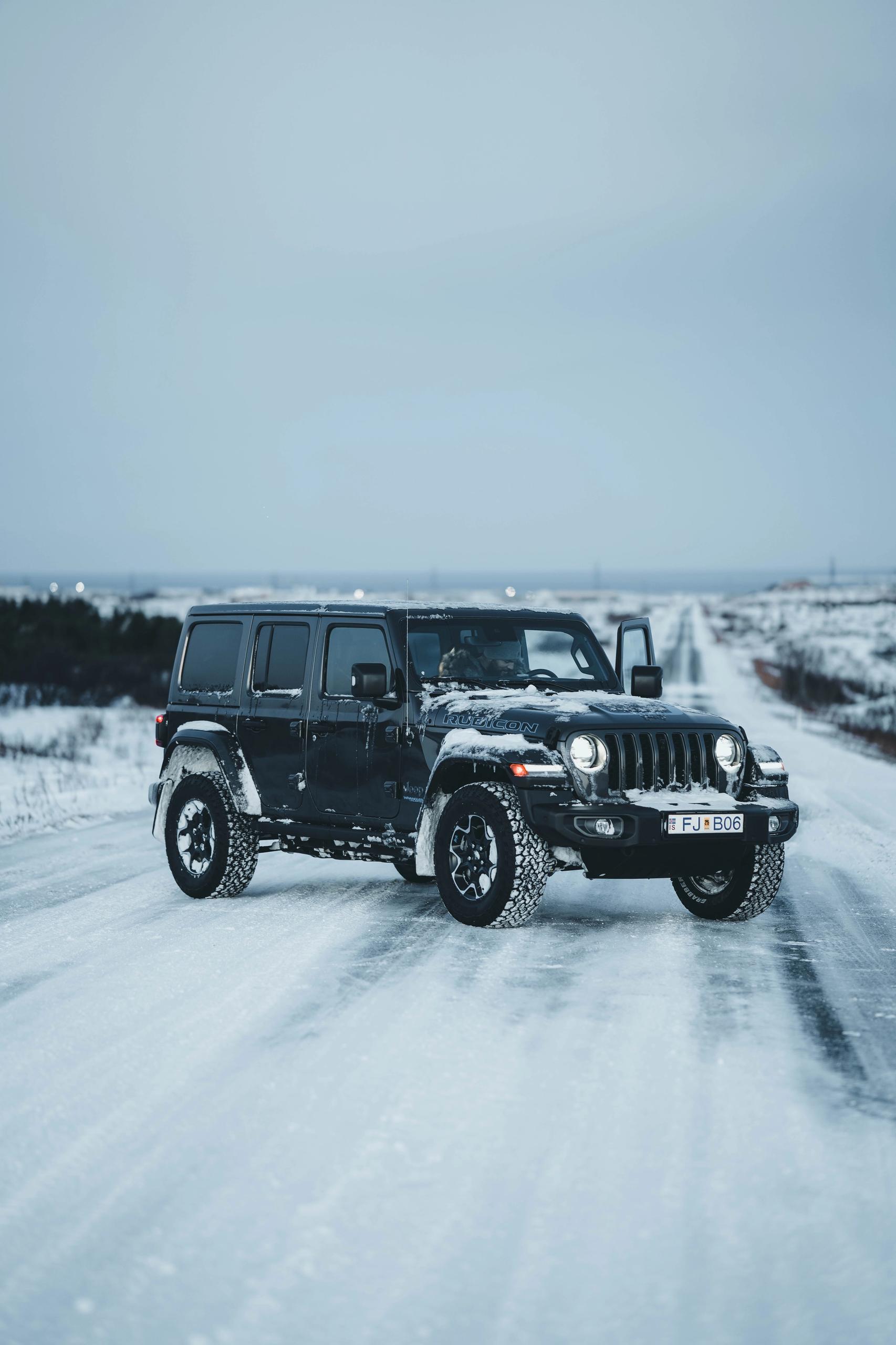 Jeep Wrangler 4x4 rental car iceland parked on a snowy road