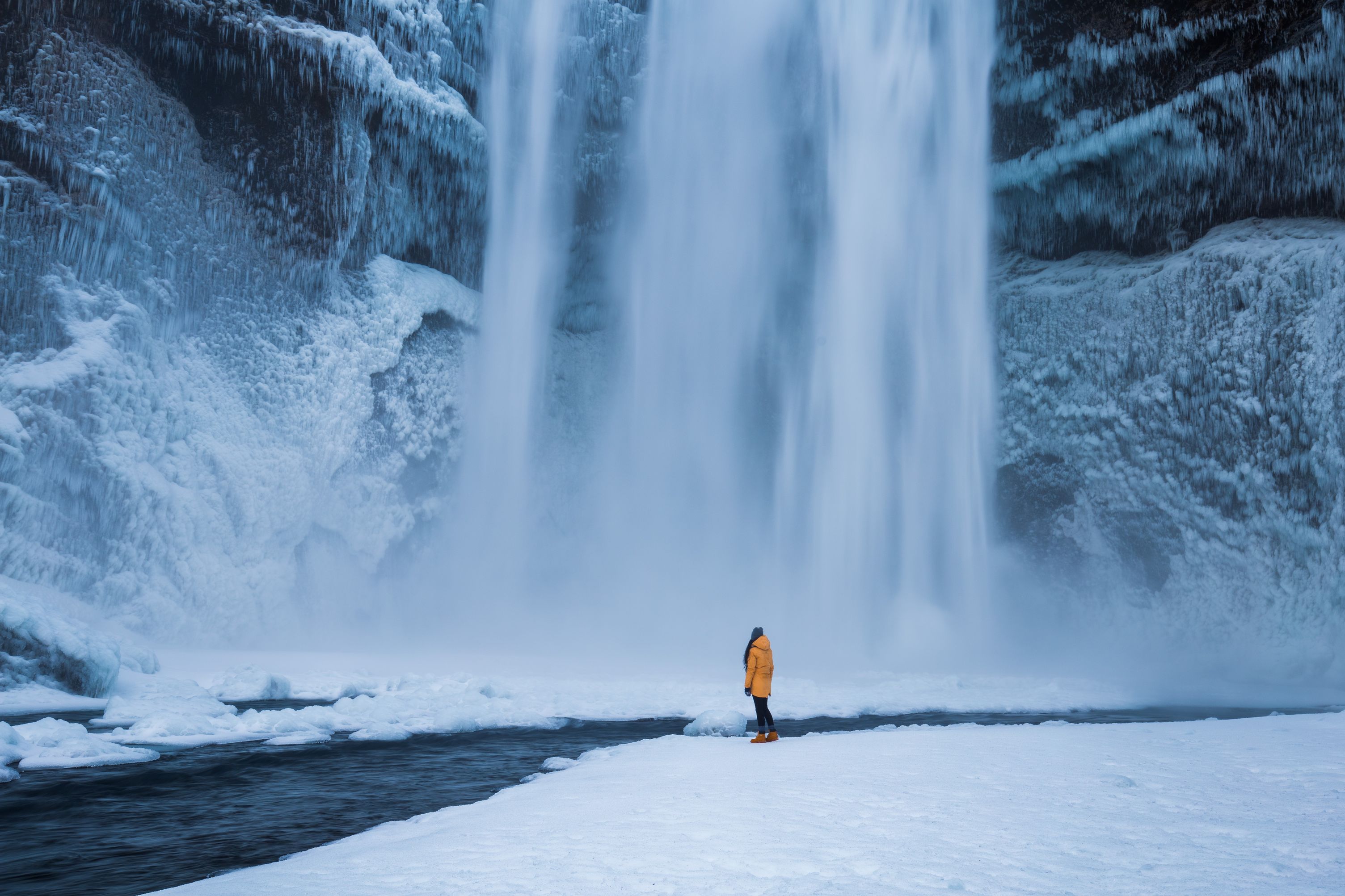 March Weather in Iceland with a person at Skogafoss waterfall