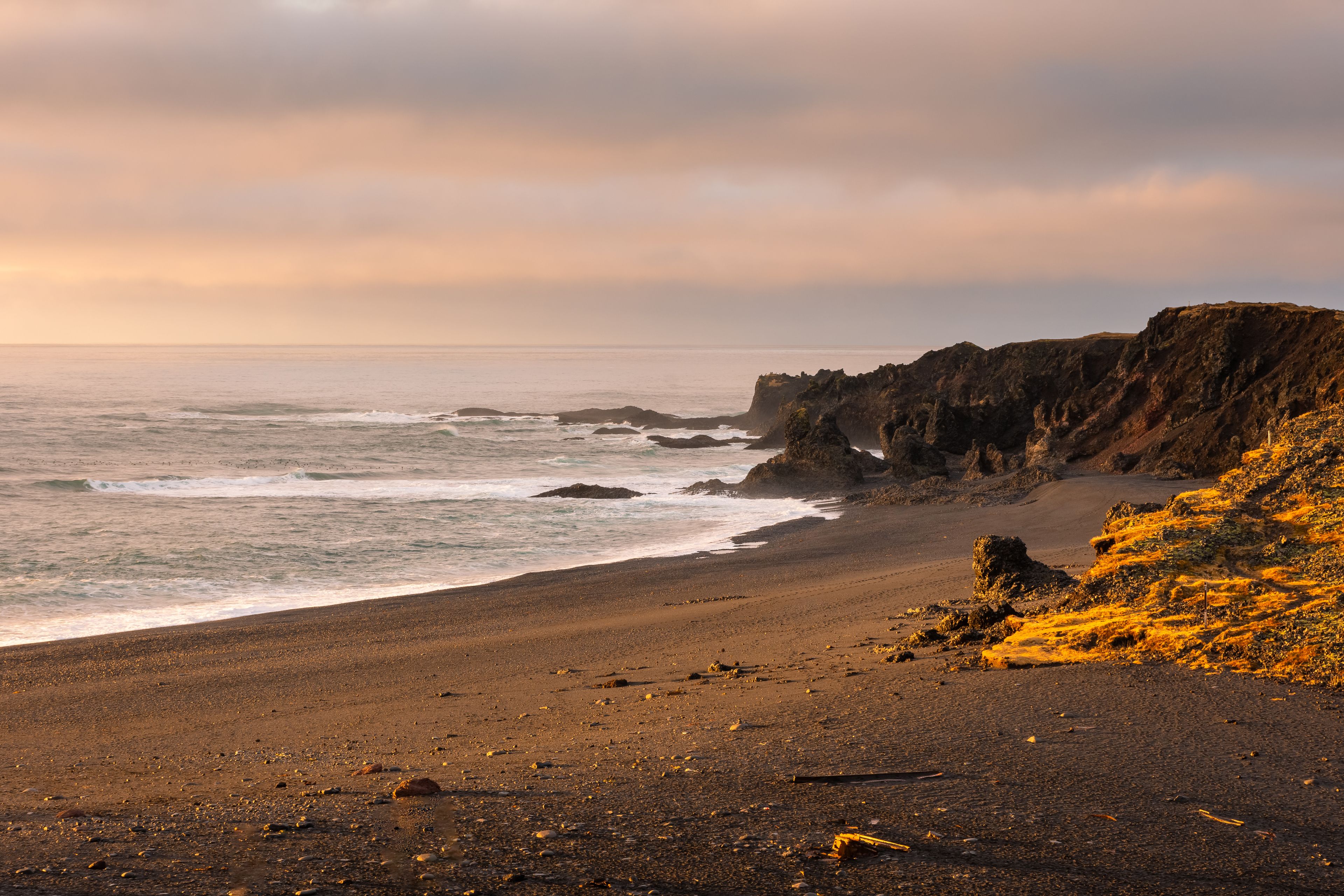 Sunset over the volcanic lava formations of Djupalonssandur beach, Iceland