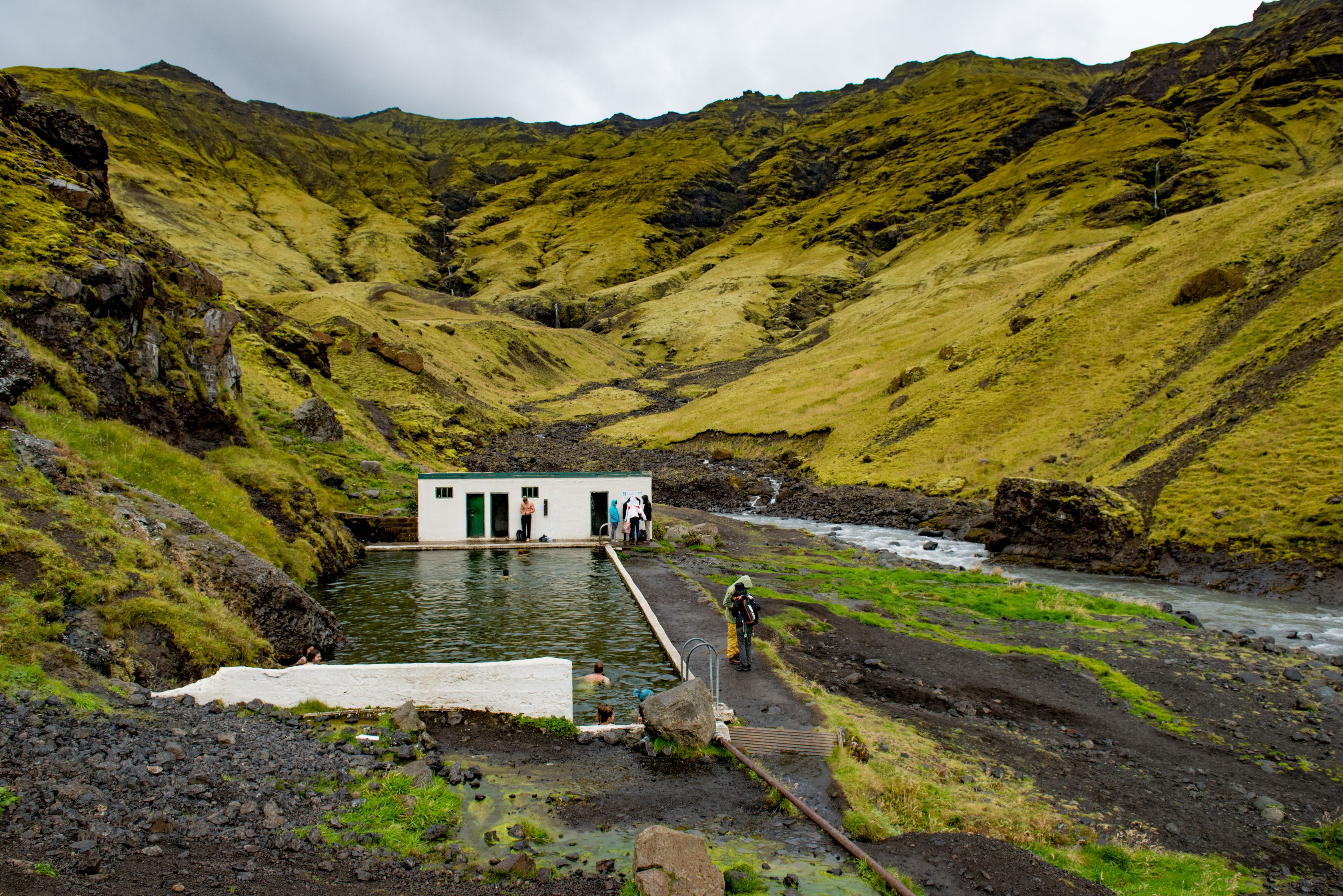 A hidden Hot Spring in Iceland near green mountains 