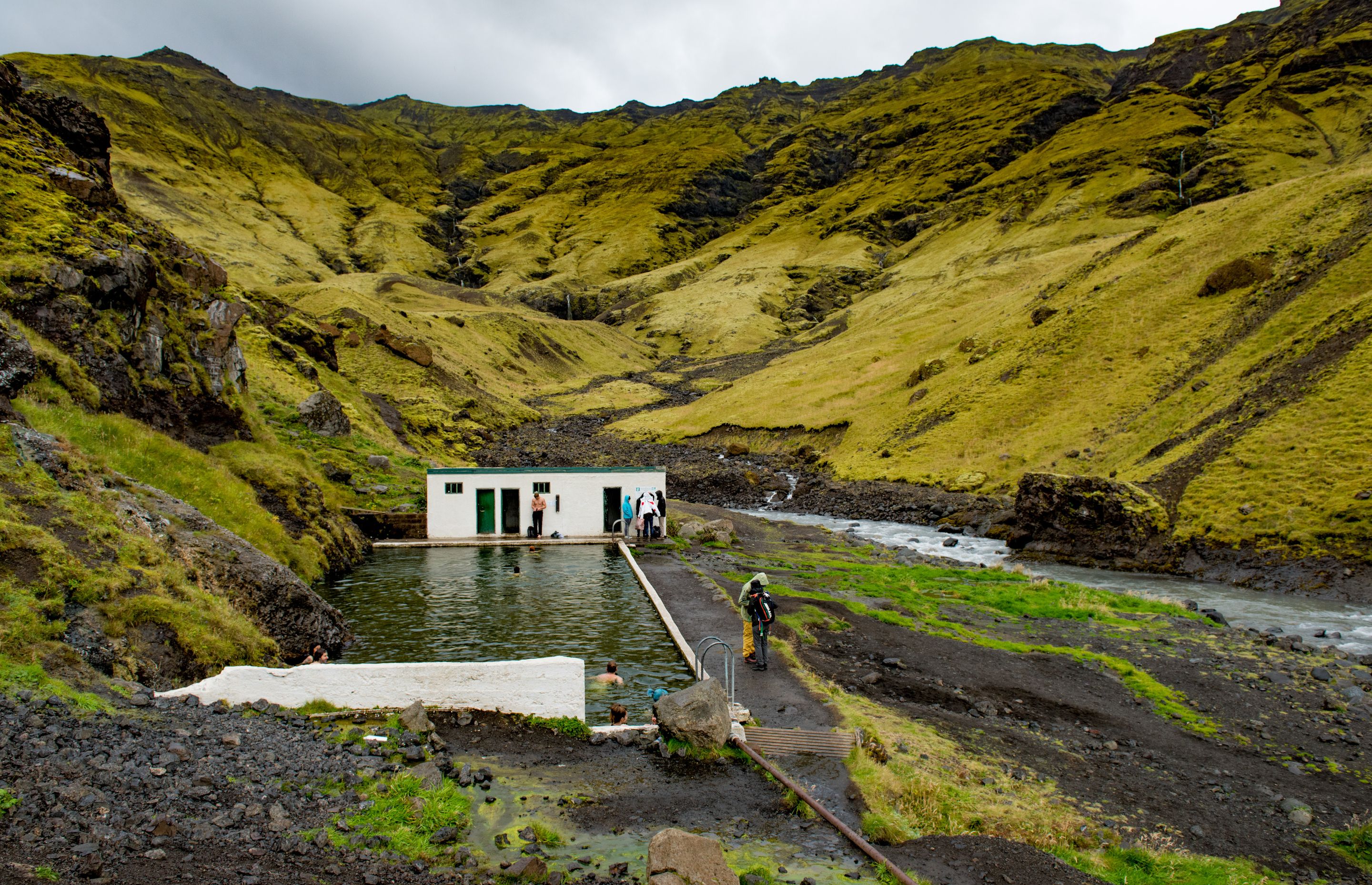 A hidden Hot Spring in Iceland near green mountains 