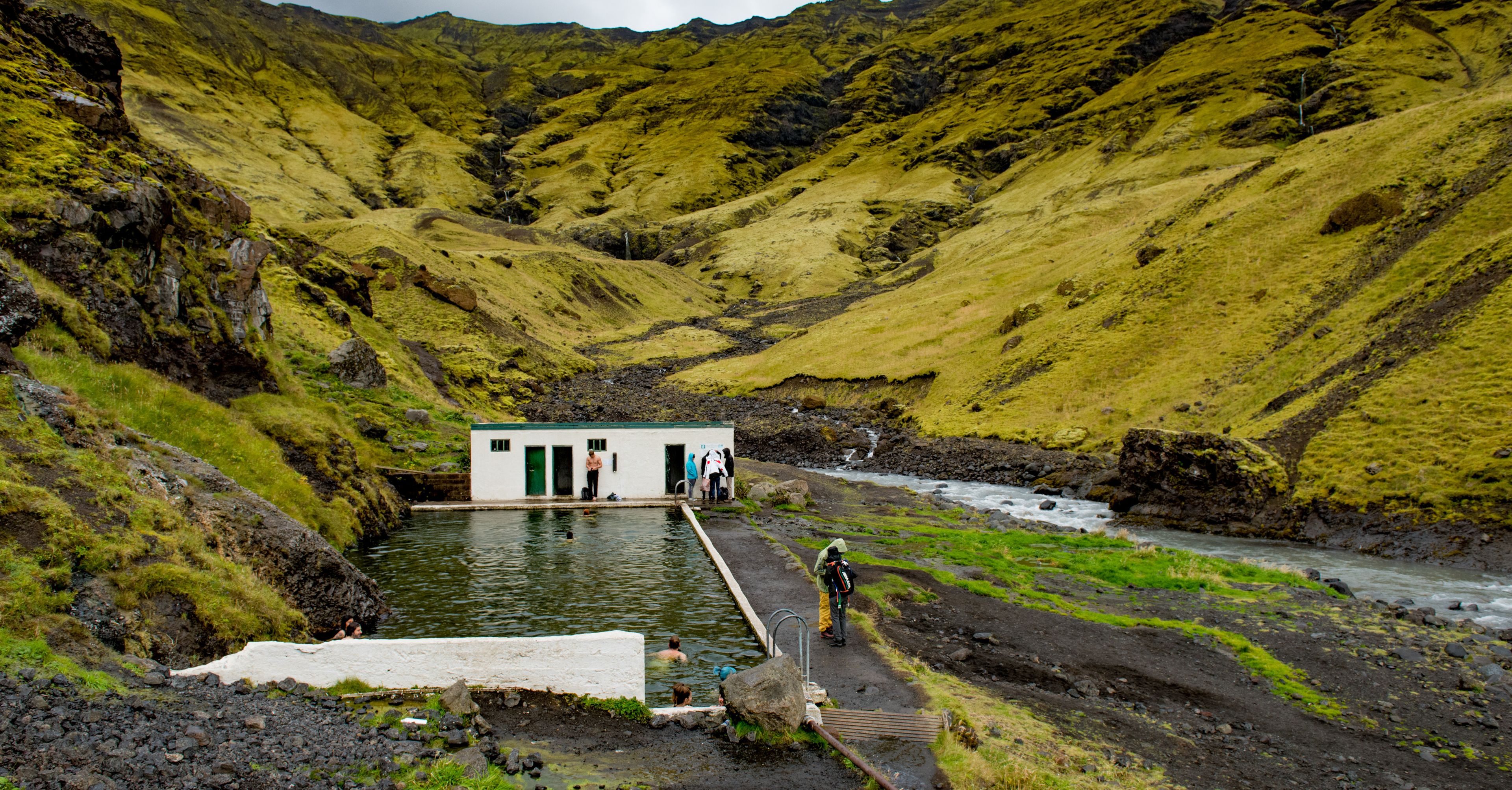 A hidden Hot Spring in Iceland near green mountains 