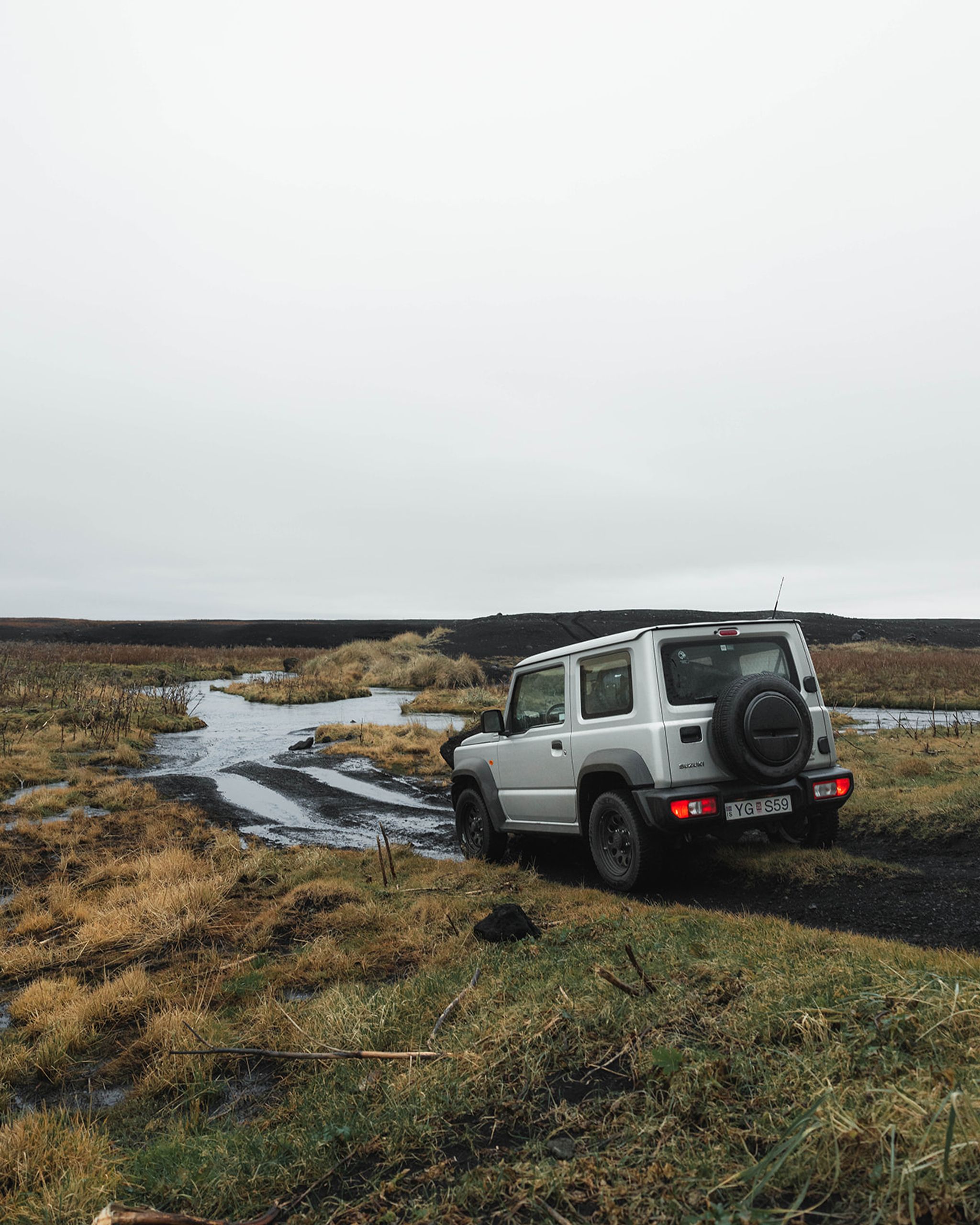 Suzuki Jimny rental car traversing an F road in the Icelandic wilderness.
