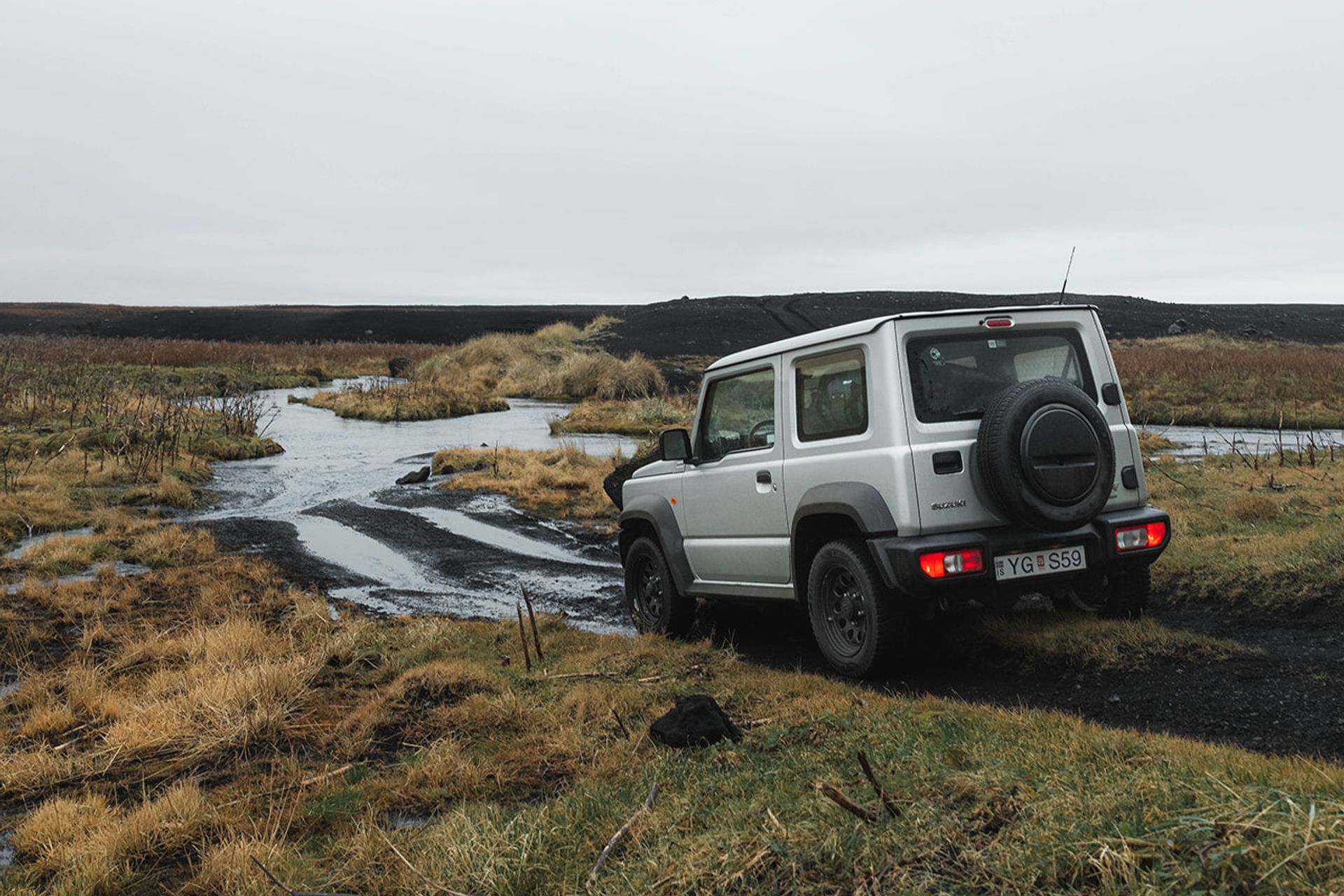 Suzuki Jimny rental car traversing an F road in the Icelandic wilderness.