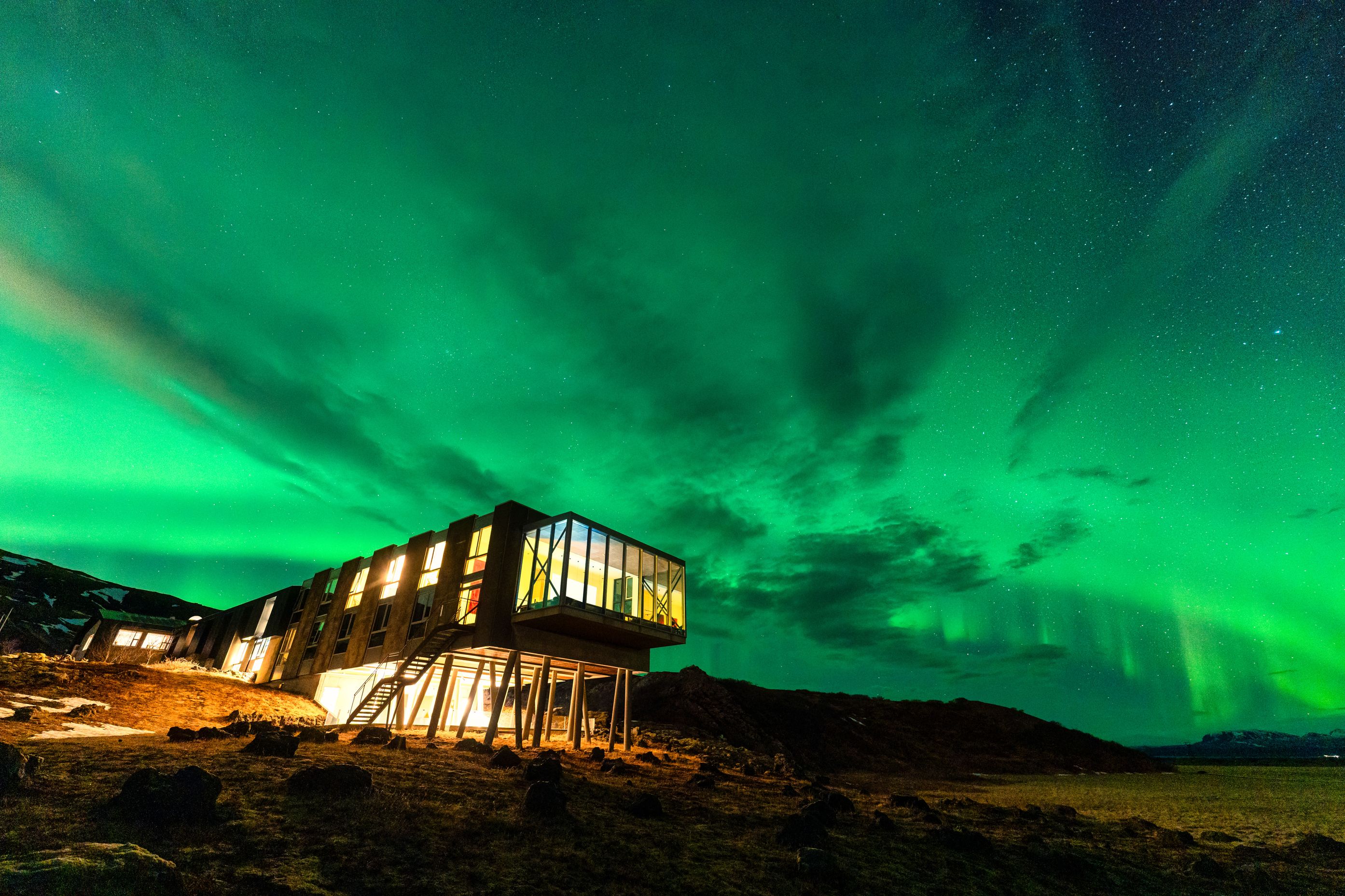 Northern lights glowing over luxury hotel in Iceland