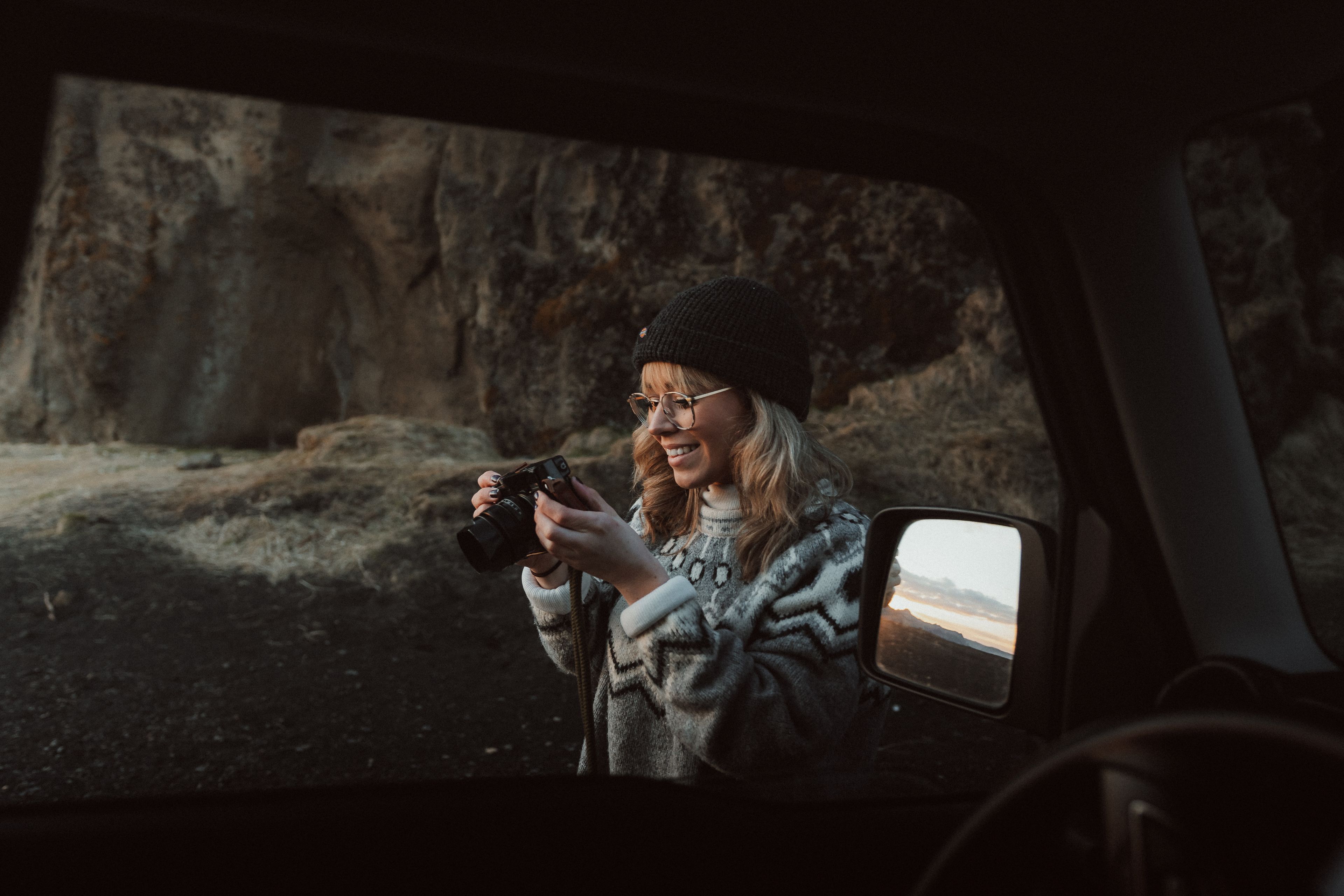 Young woman taking photos on her camera in iceland
