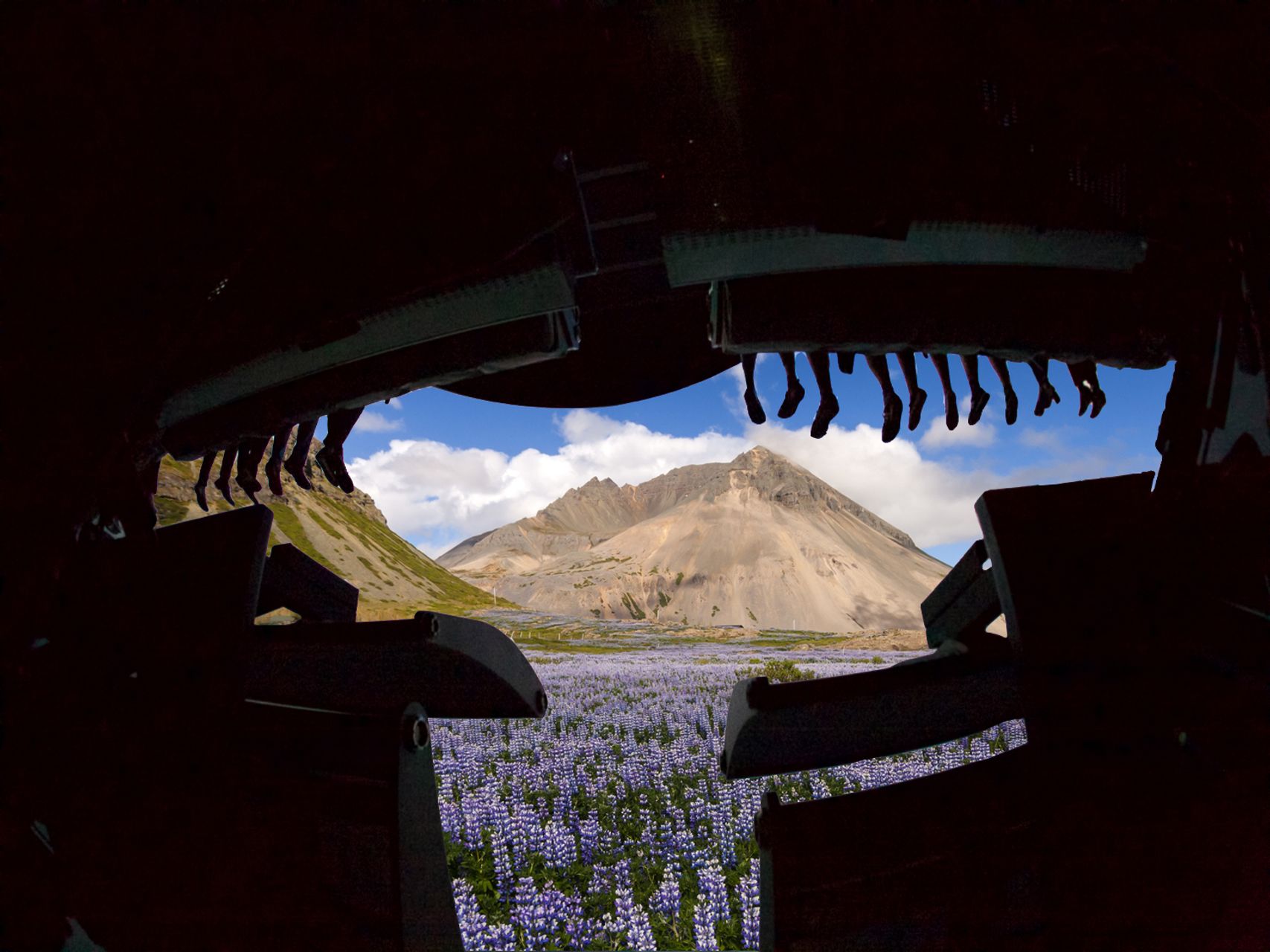 FlyOver Iceland riders feet dangling wiht a mountain in the background