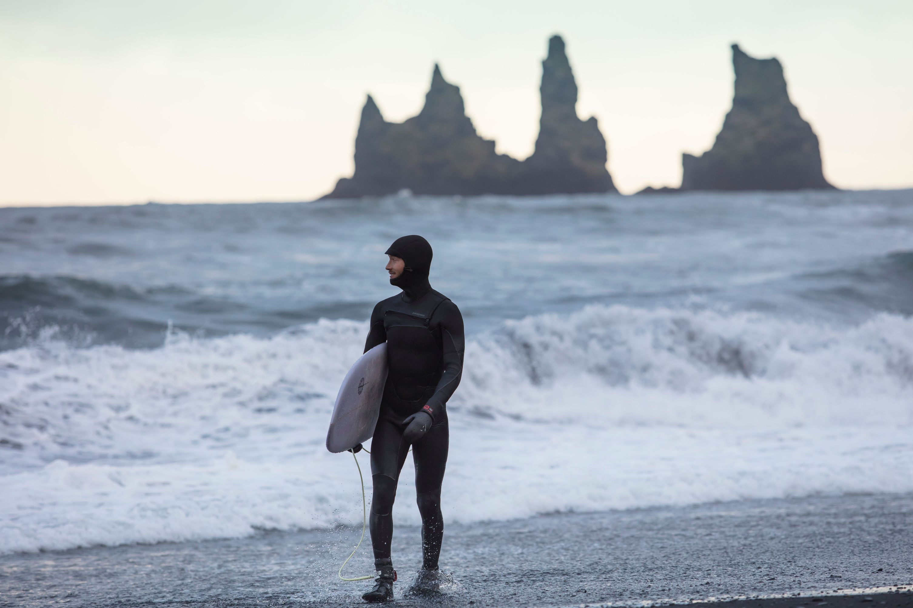 Man who surfs in a cold weather in Iceland
