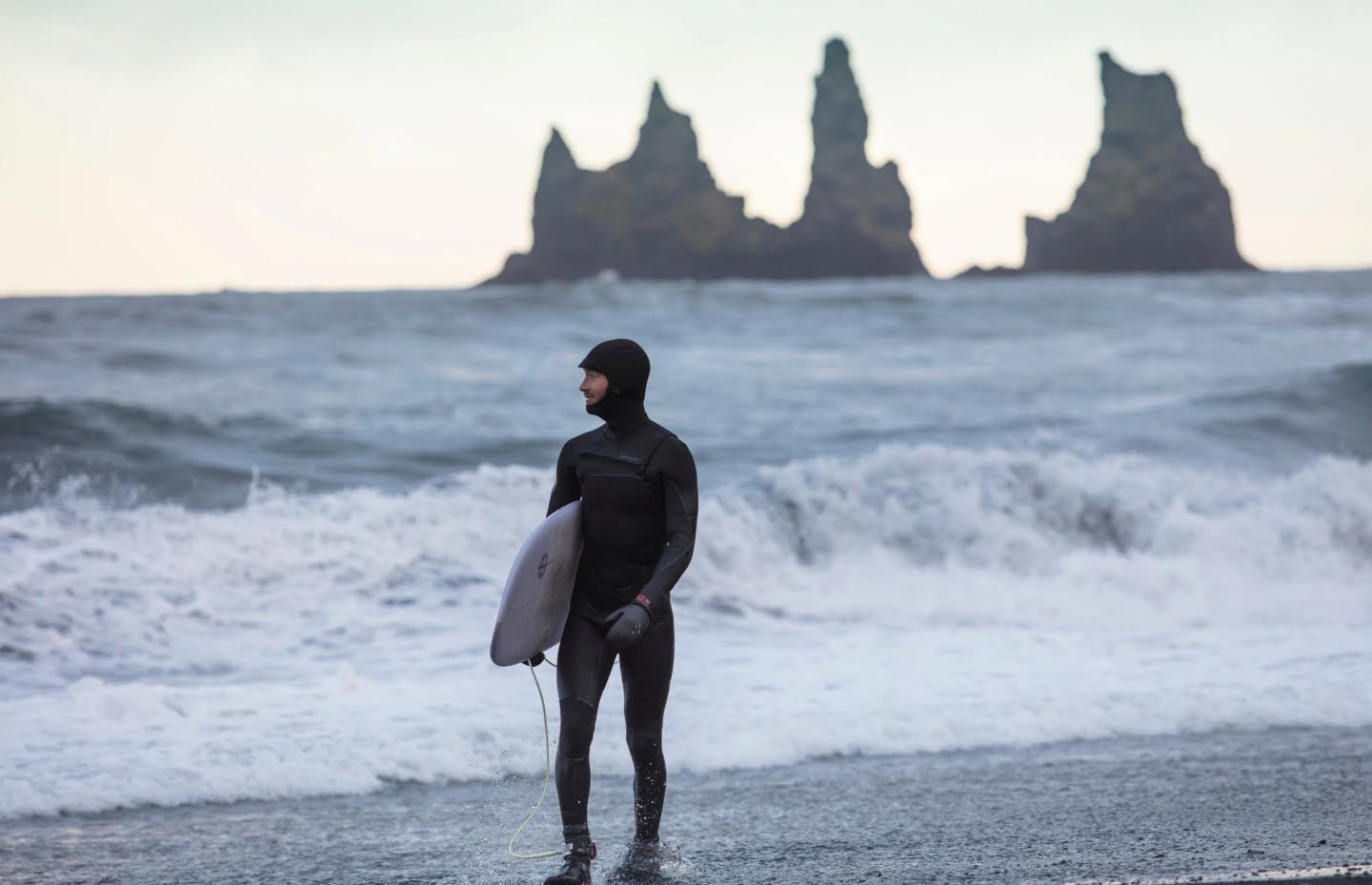 Man who surfs in a cold weather in Iceland