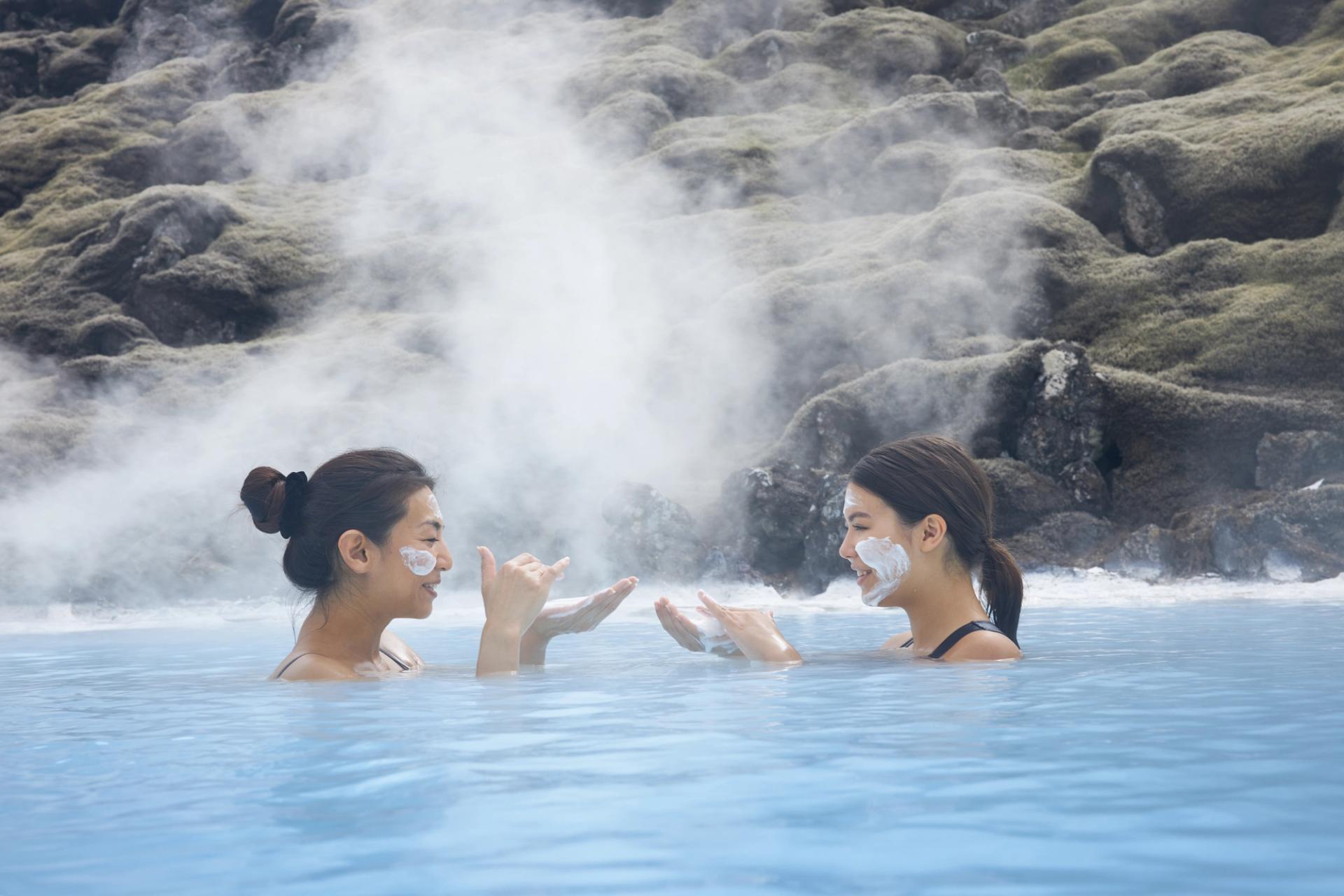 two friends putting on a face mask in the blue lagoon