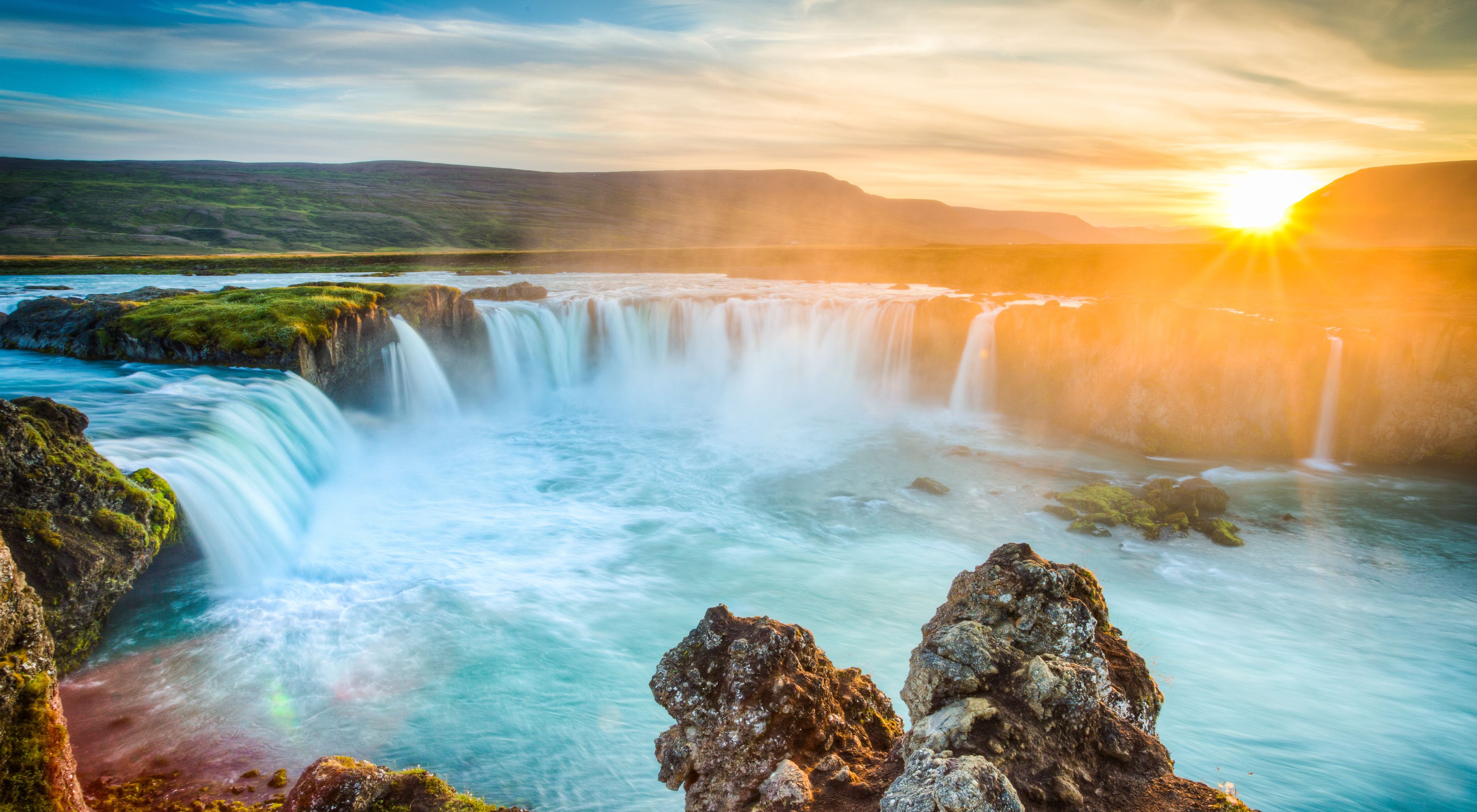Panoramic view on the Godafoss waterfall and its green landscapes ,accompanied by a beautiful sunset