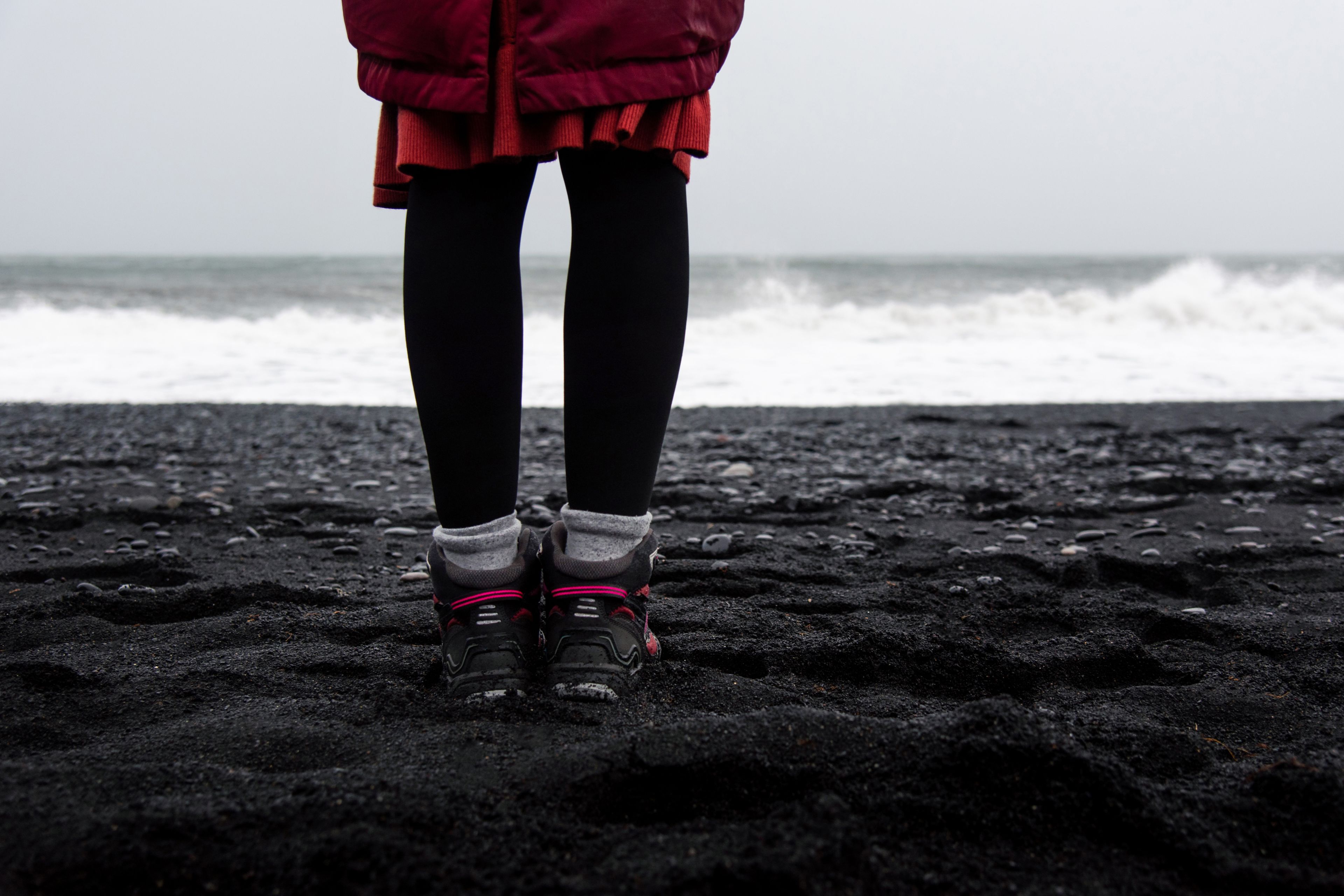 Woman wearing good shoes on black sand beach in iceland