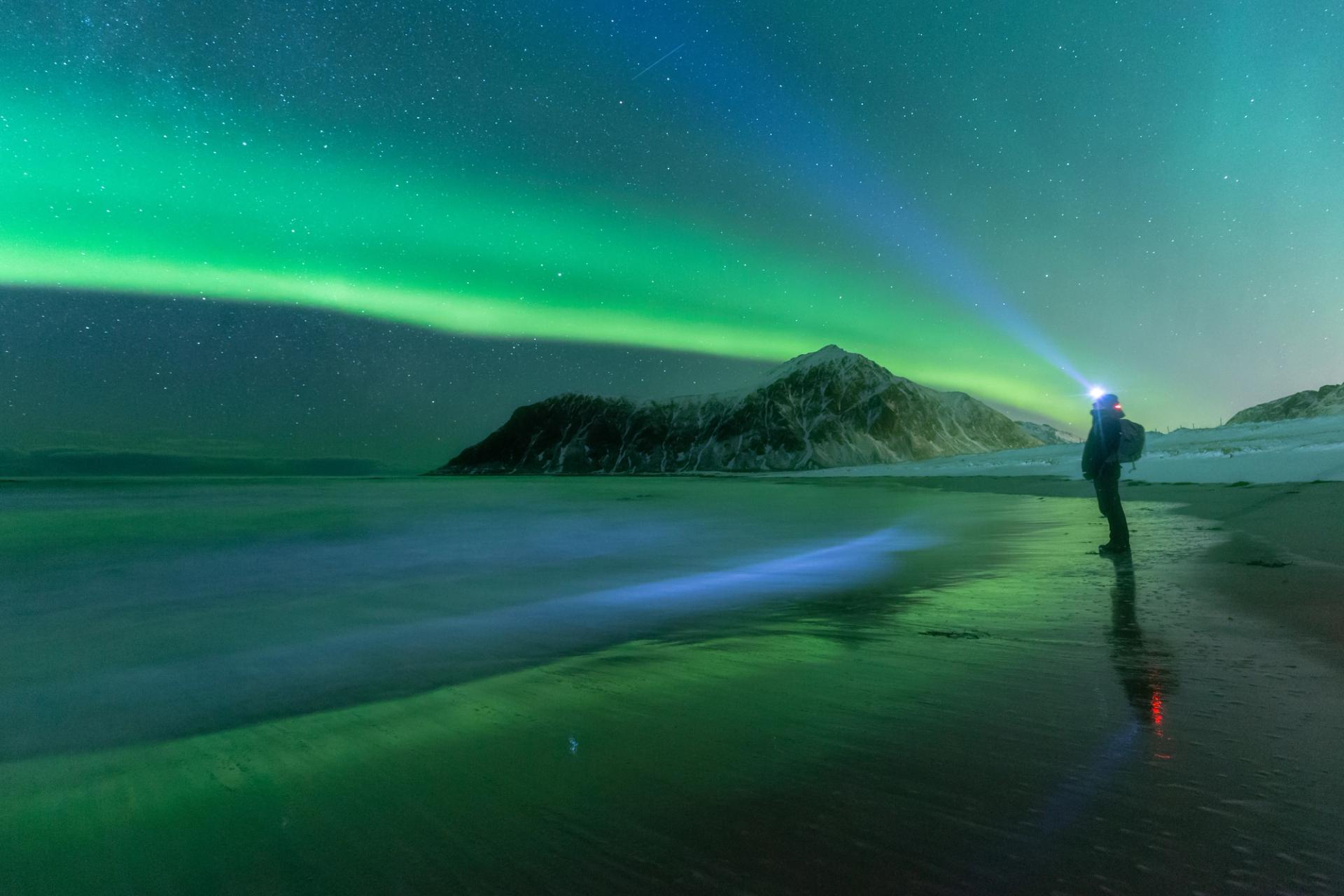 November in iceland: A picture of a person looking at the Northern Lights in Iceland during off season