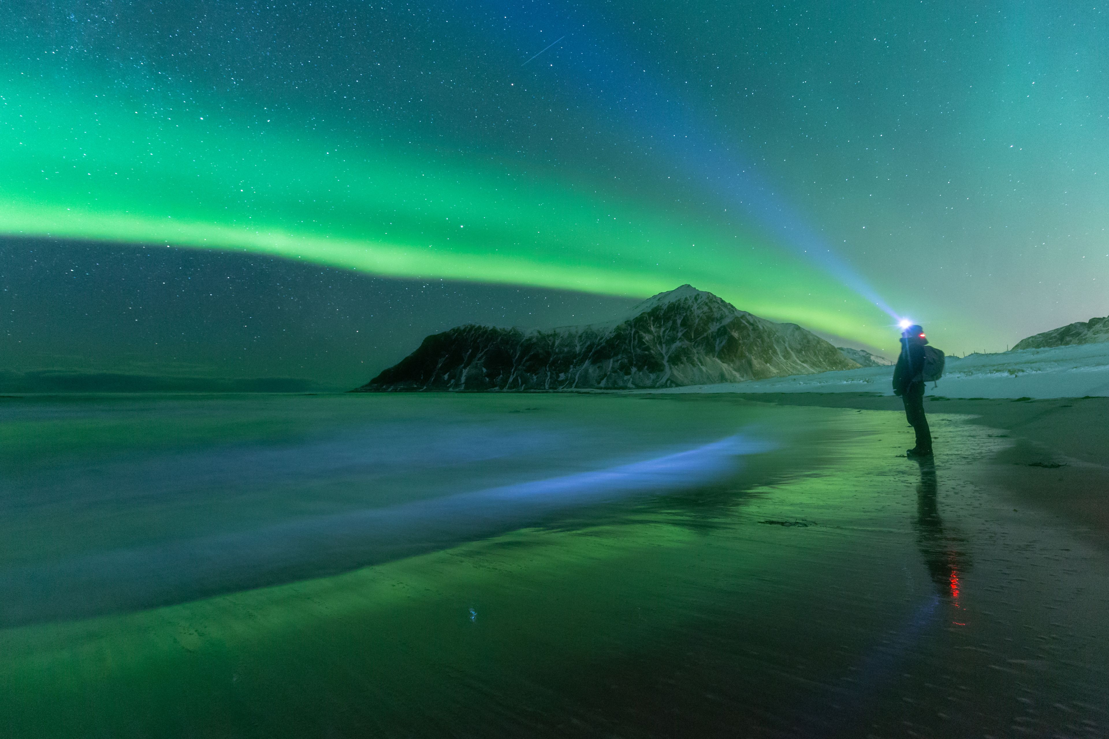 November in Island: Ein Bild einer Person, die außerhalb der Saison die Nordlichter in Island betrachtet