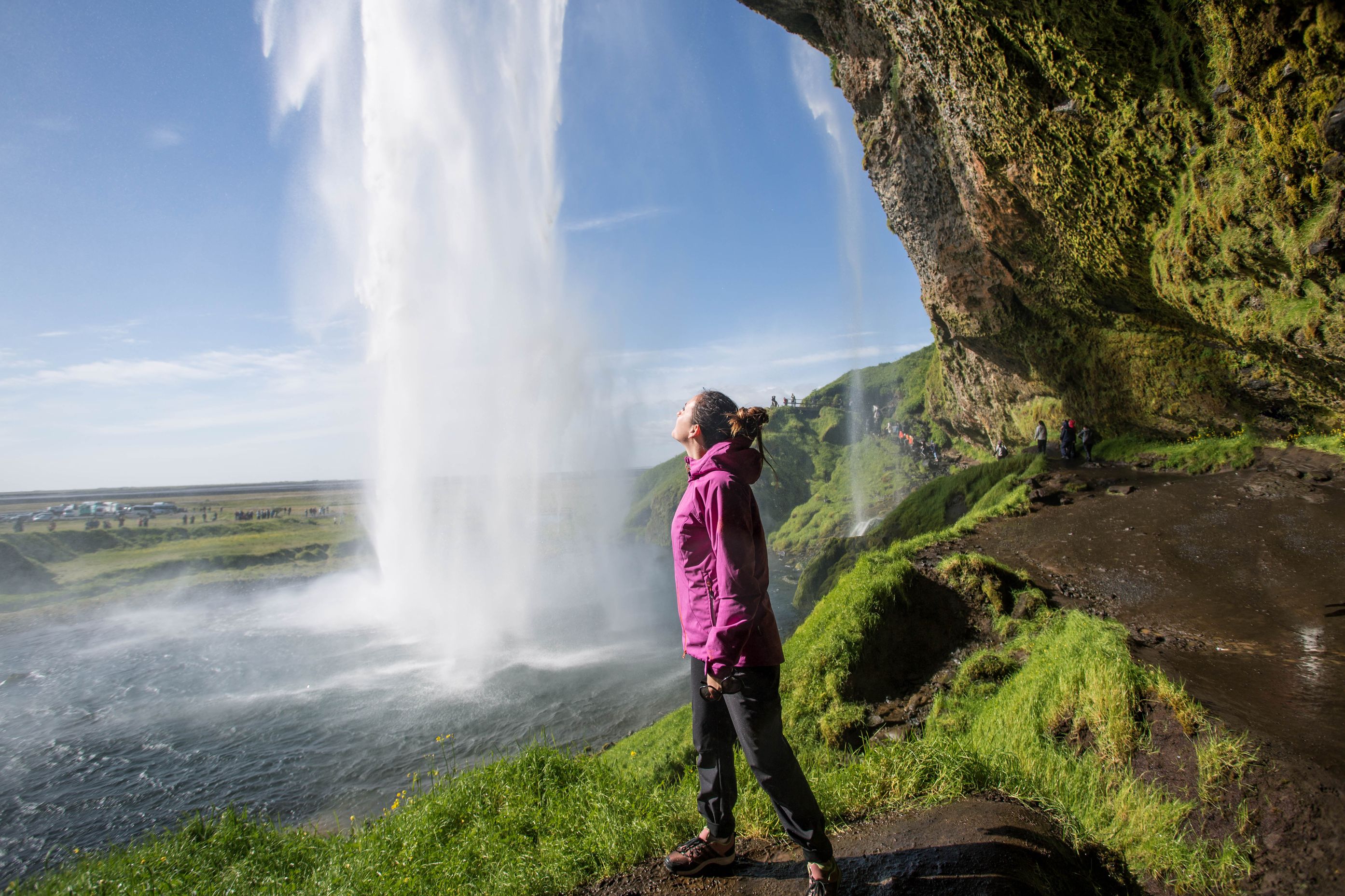 Woman behind Seljalandsfoss waterfall, Iceland