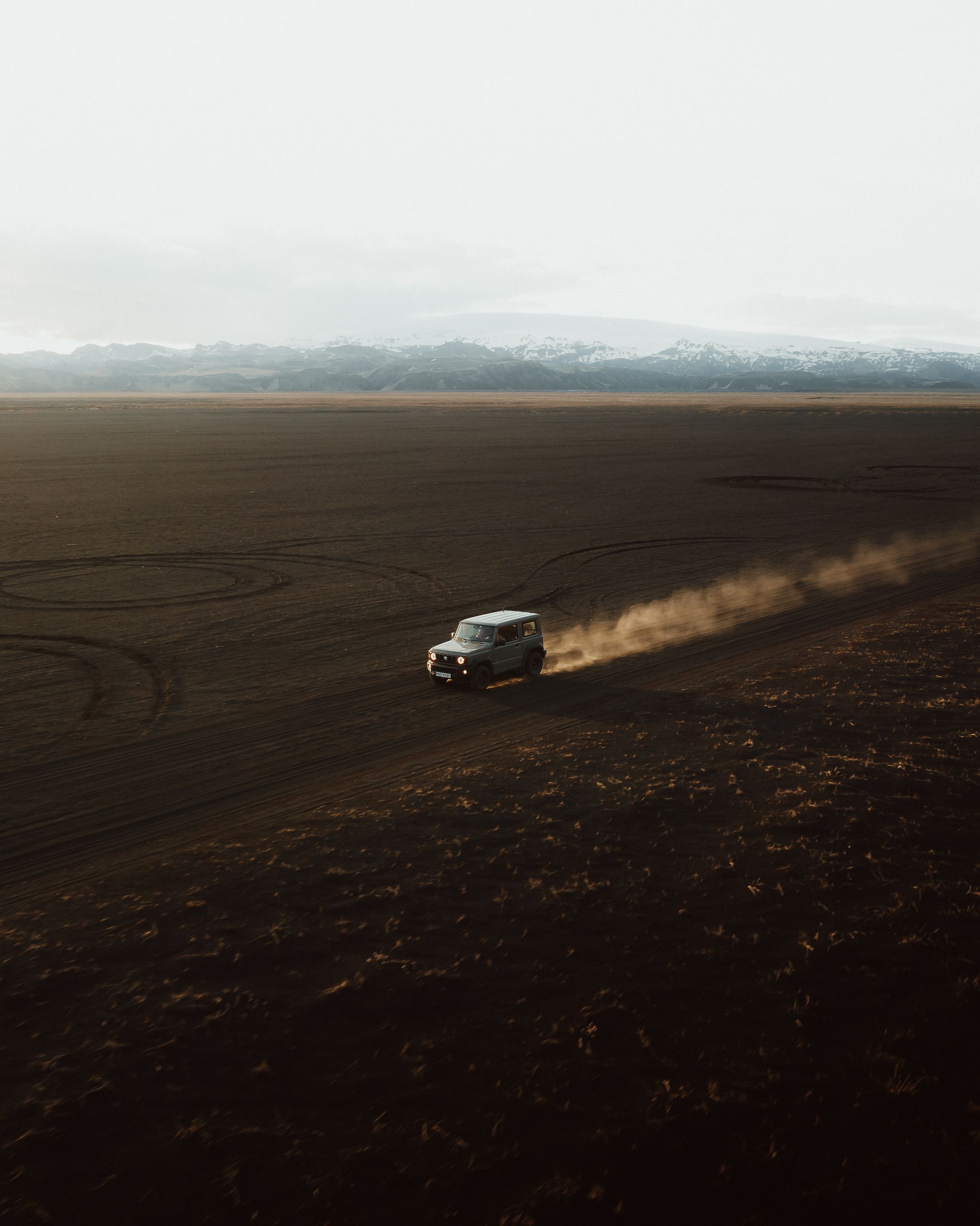 A 4x4 rental car maneuvering along an F-road in the wild landscapes of Iceland