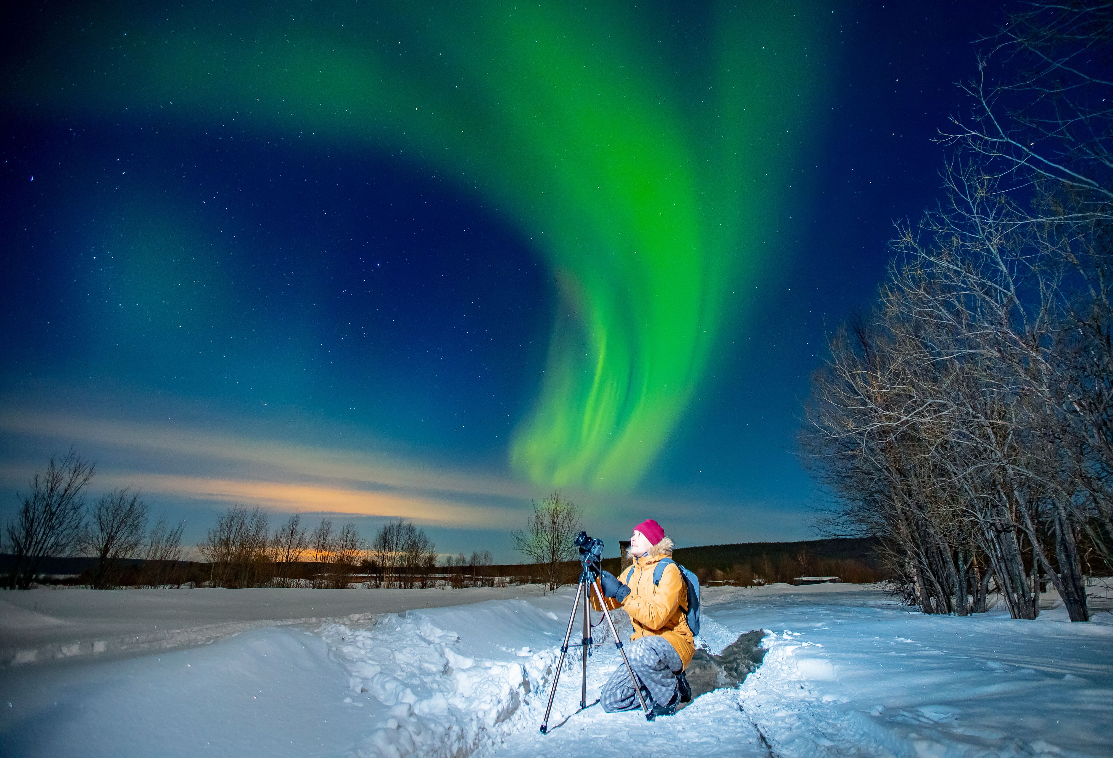 Hombre fotografiando la aurora boreal en Islandia