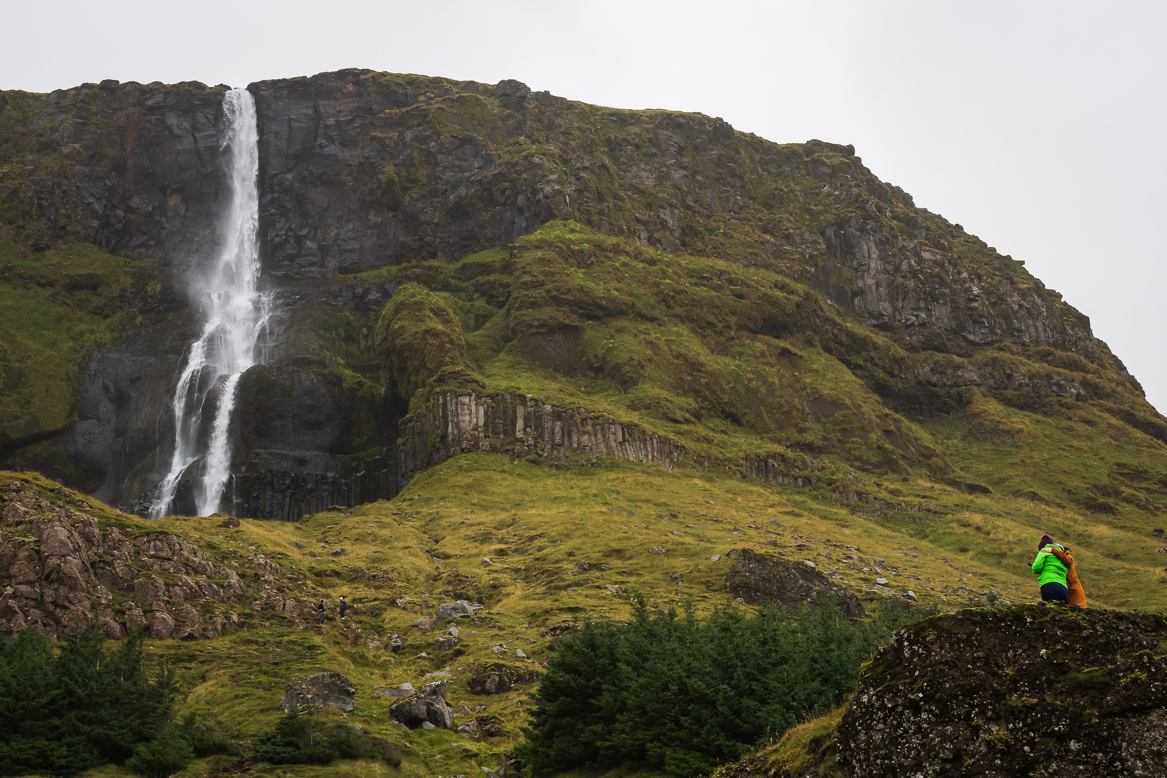 Two people admiring Bjarnarfoss Waterfall