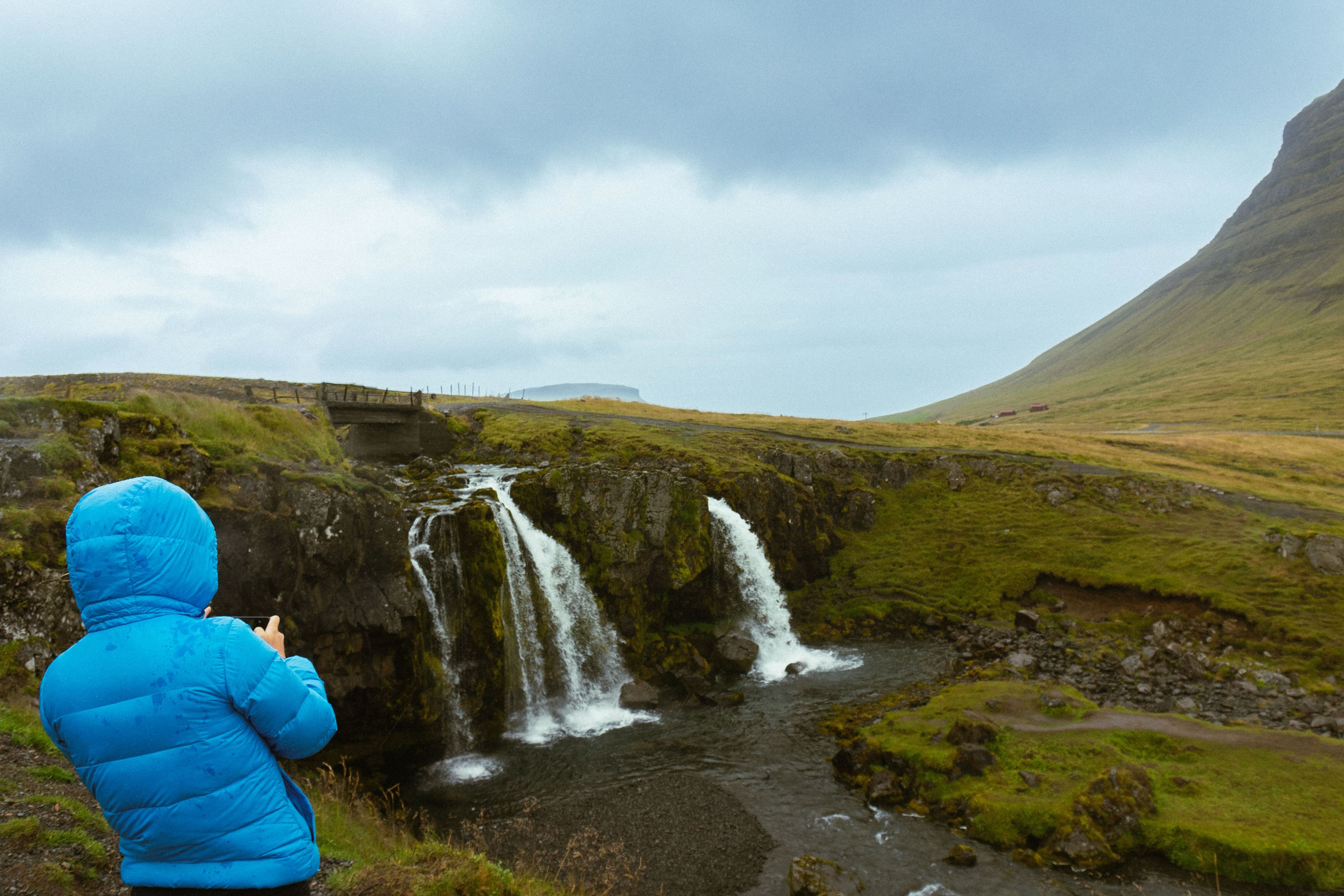 Tourist photographing Kirkjufellsfoss Waterfall