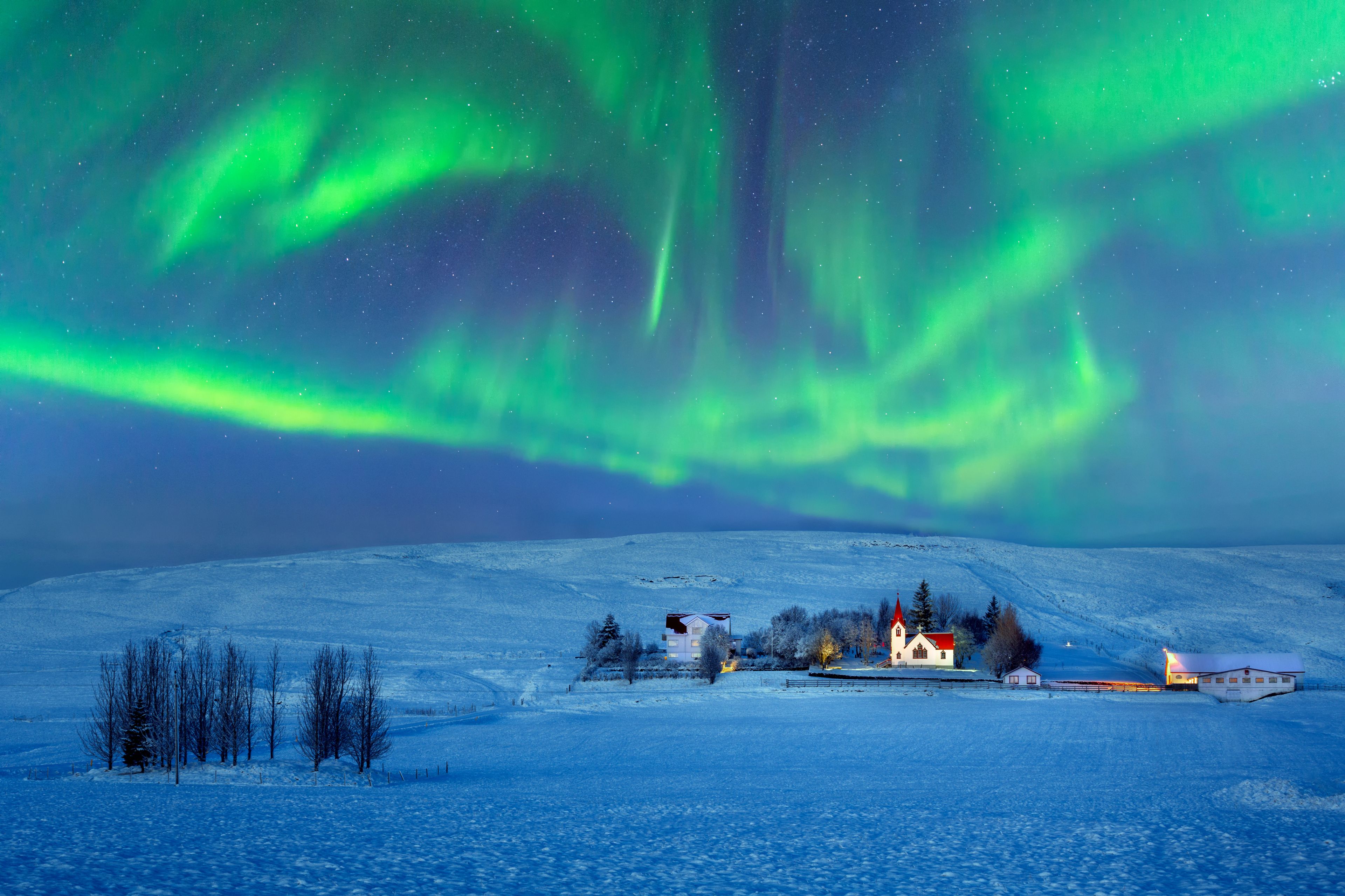 Aurora boreal sobre un pequeño poblado en Islandia