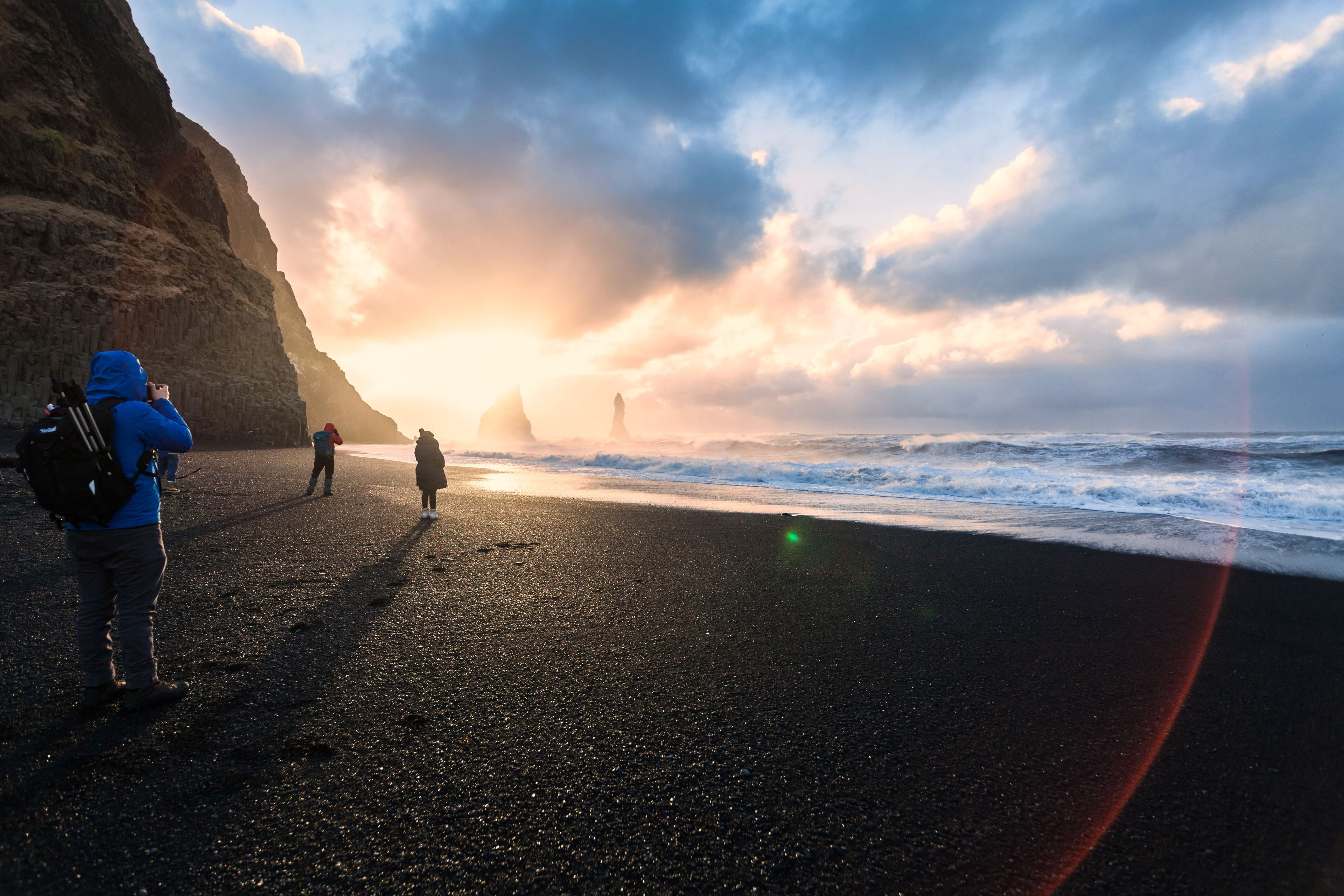 Gente en Reynisfjara al atardecer