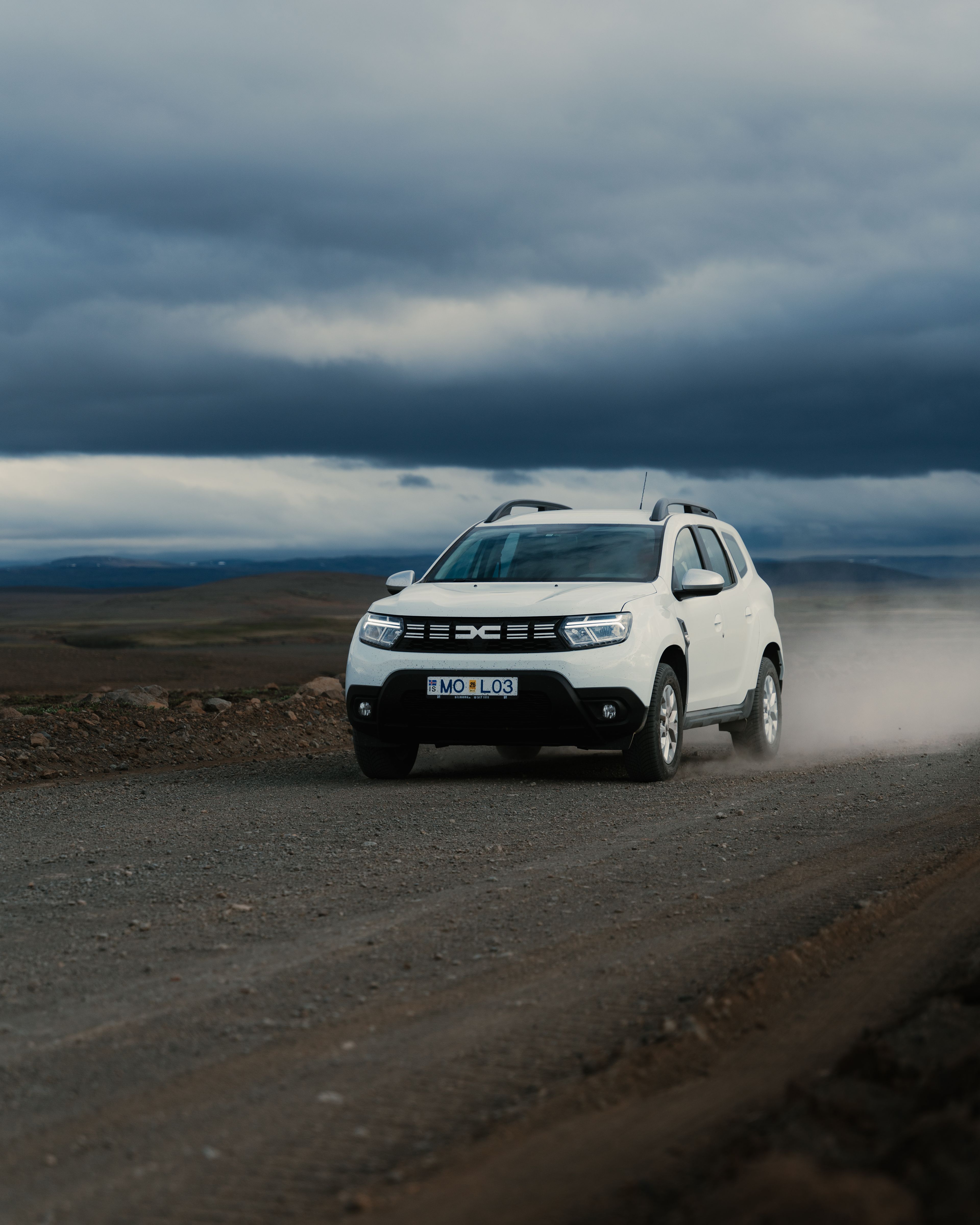 Dacia Duster location conduit sur une route de gravier en Islande
