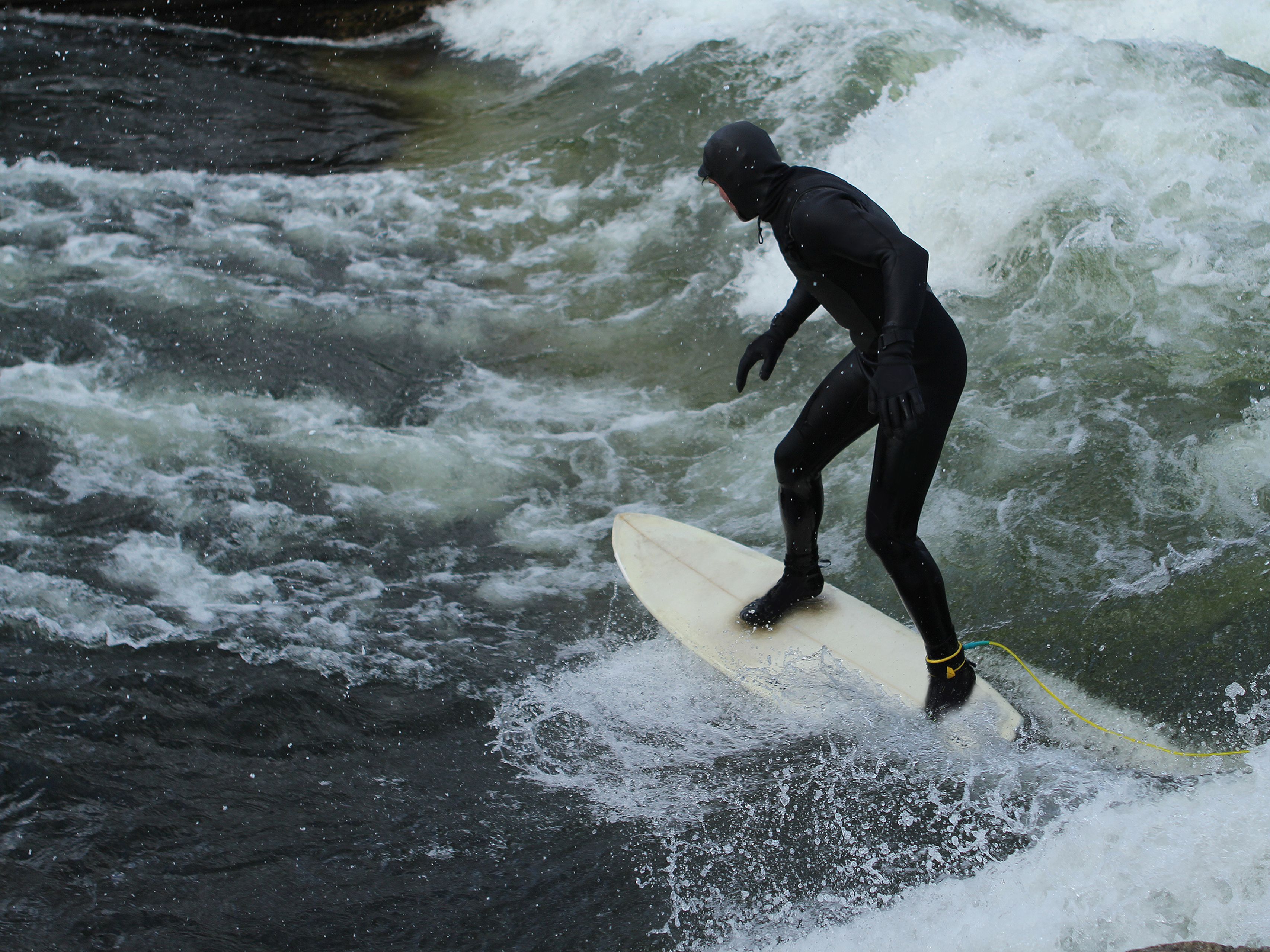 Man in black wetsuit is surfing in waves