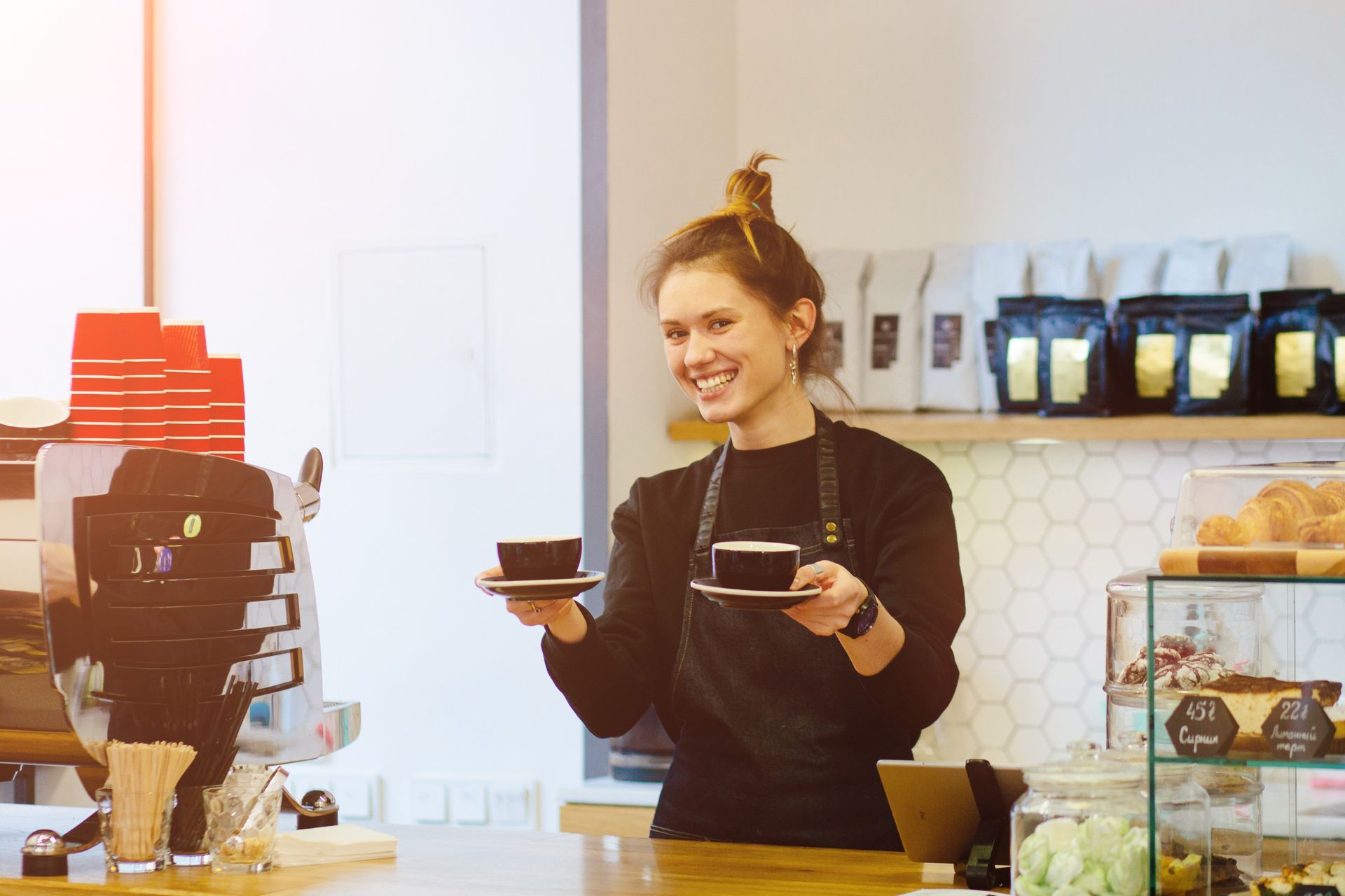 Friendly waitress holding a two cups of coffee at the local coffee shop