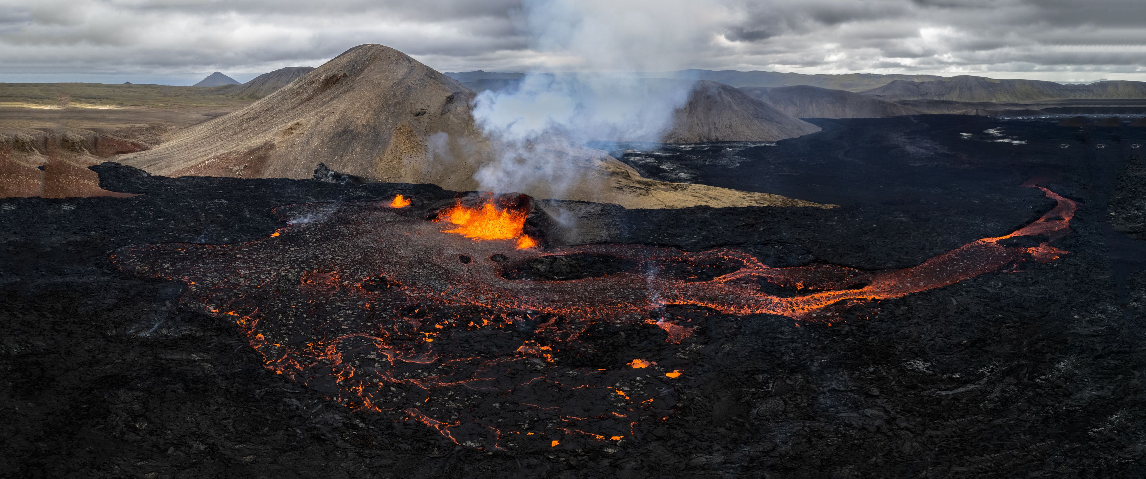 A view of famous volcanoes, Meradalir valley with volcanic activity in the background