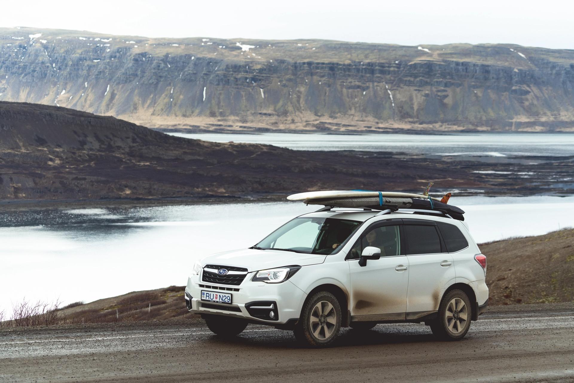 A Subaru Forester on a road in Iceland with a roof box
