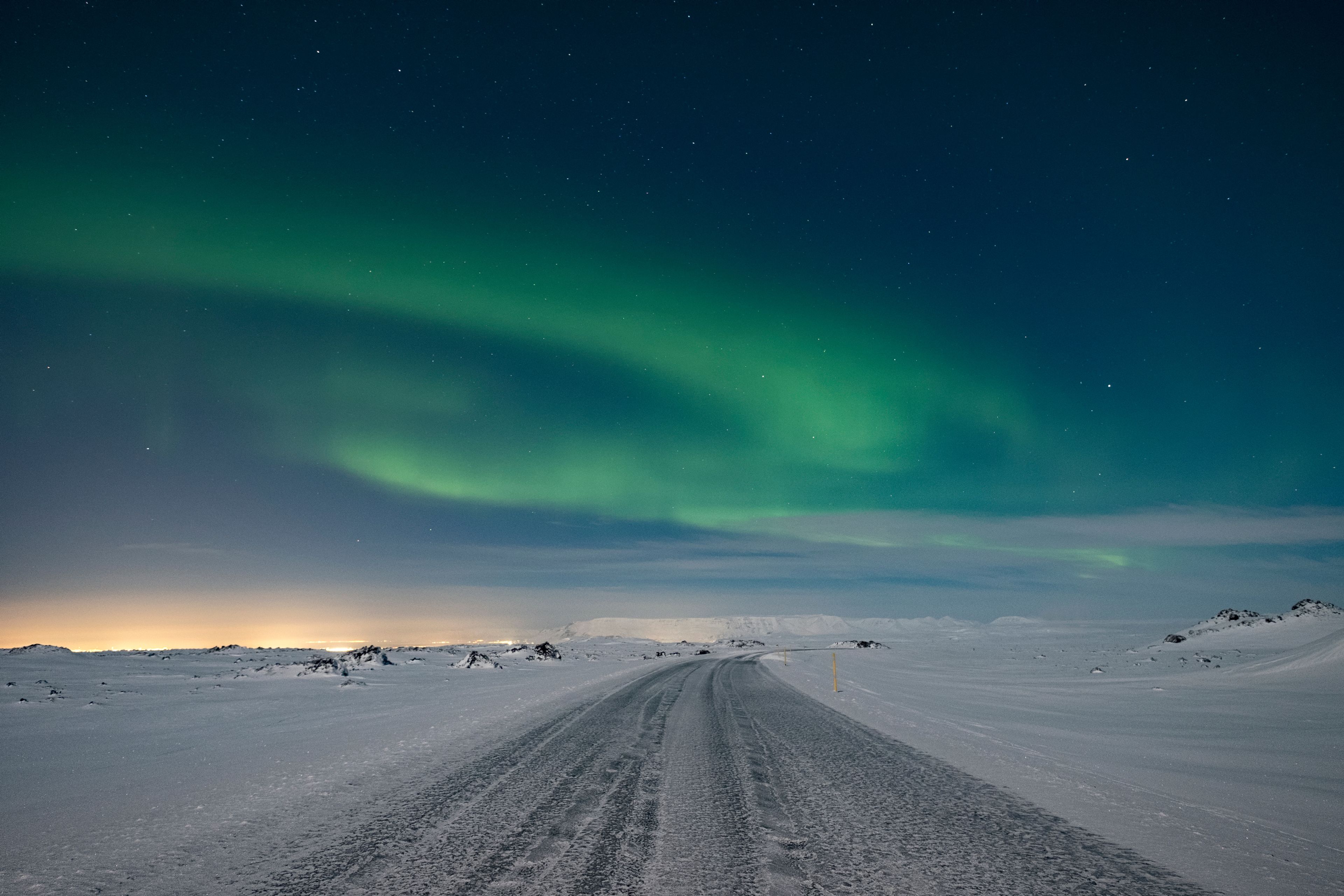 Expect snow while driving the ring road with northern lights dancing in the sky