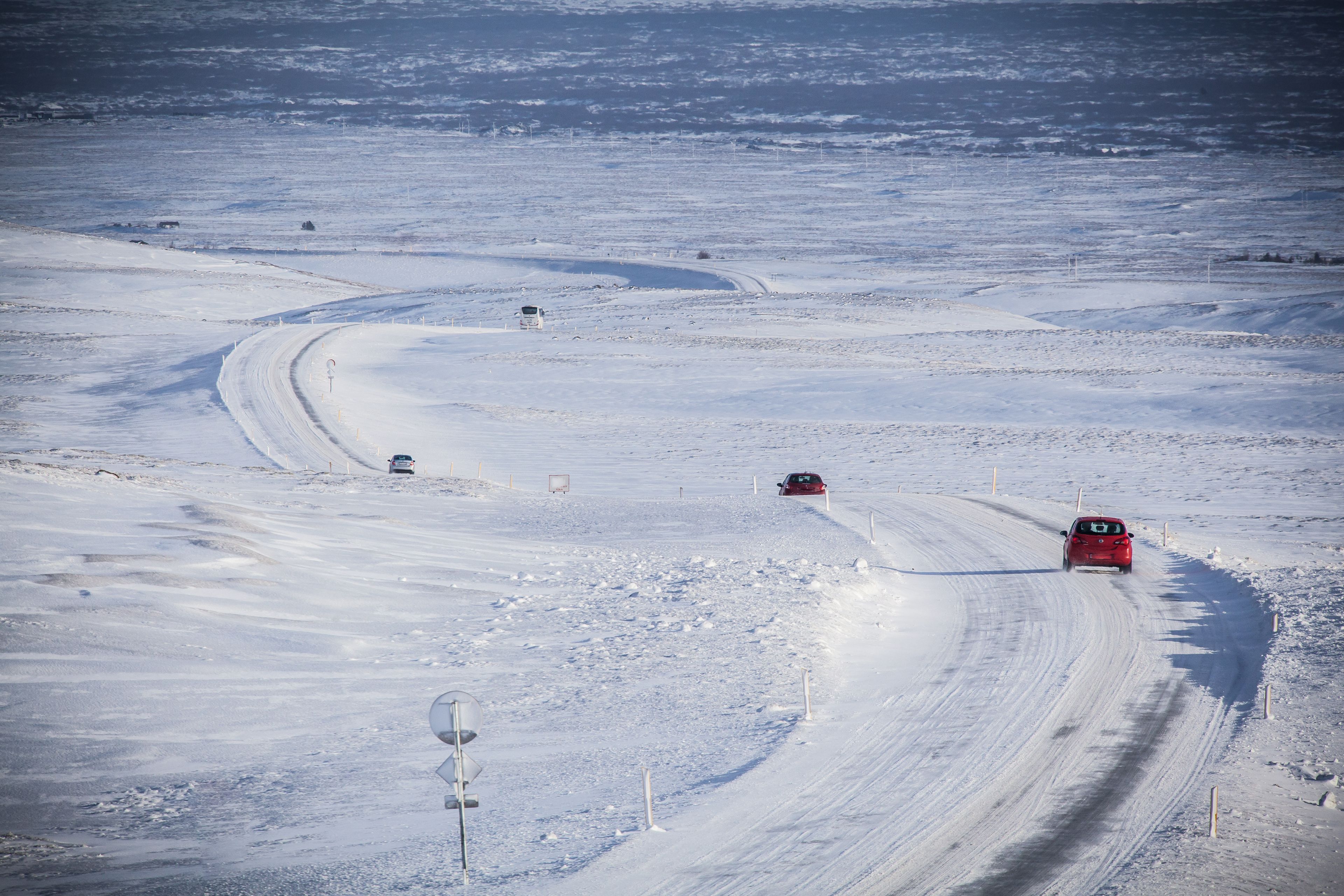 A view of weather and road conditions with cars driving on a road during winter month on during Iceland weather