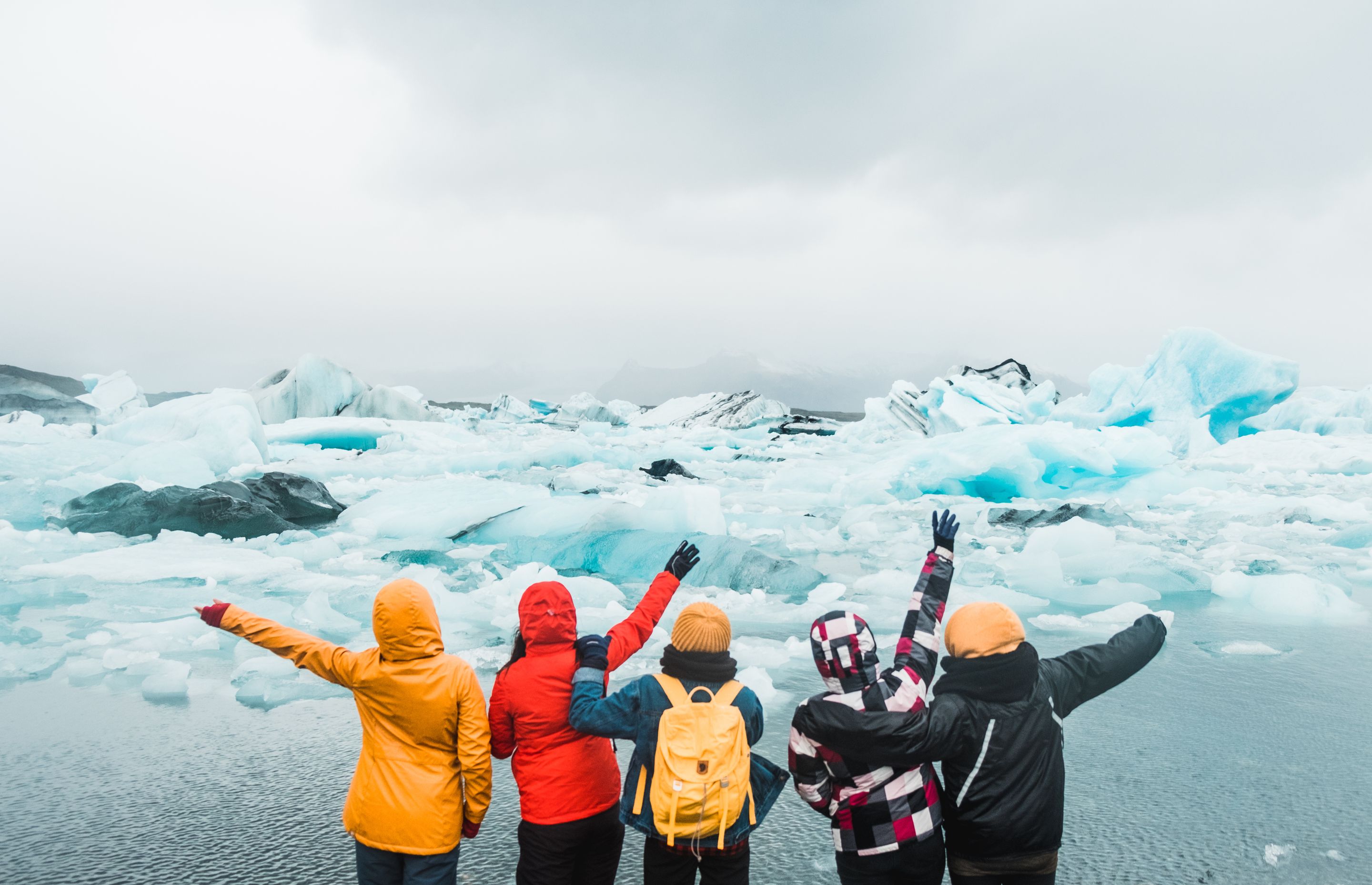 5 friends having fun standing near water in Iceland