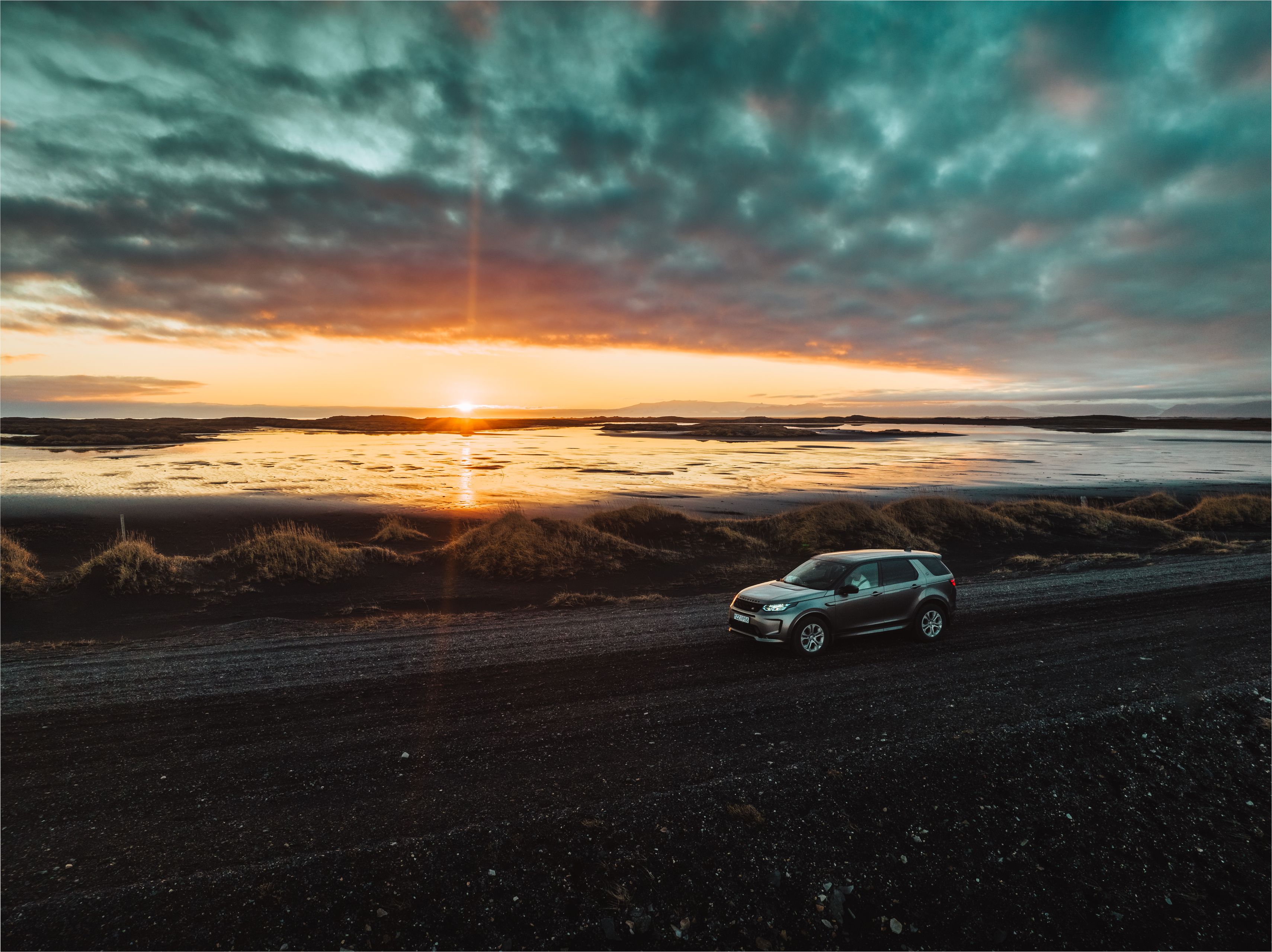 A Discovery Sport 4x4 Rental Car in Iceland looking at the sunset