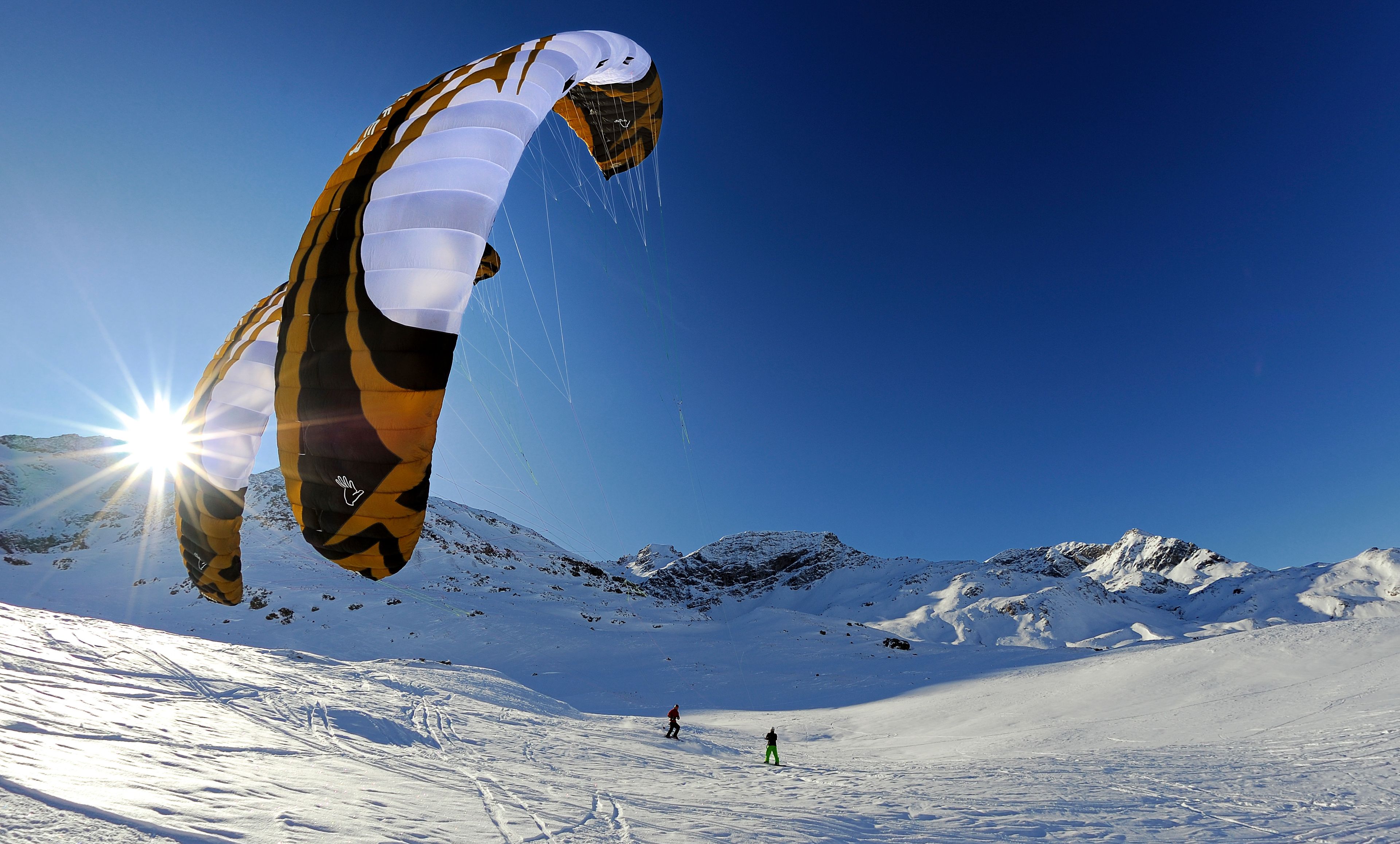 Two people snowkiting